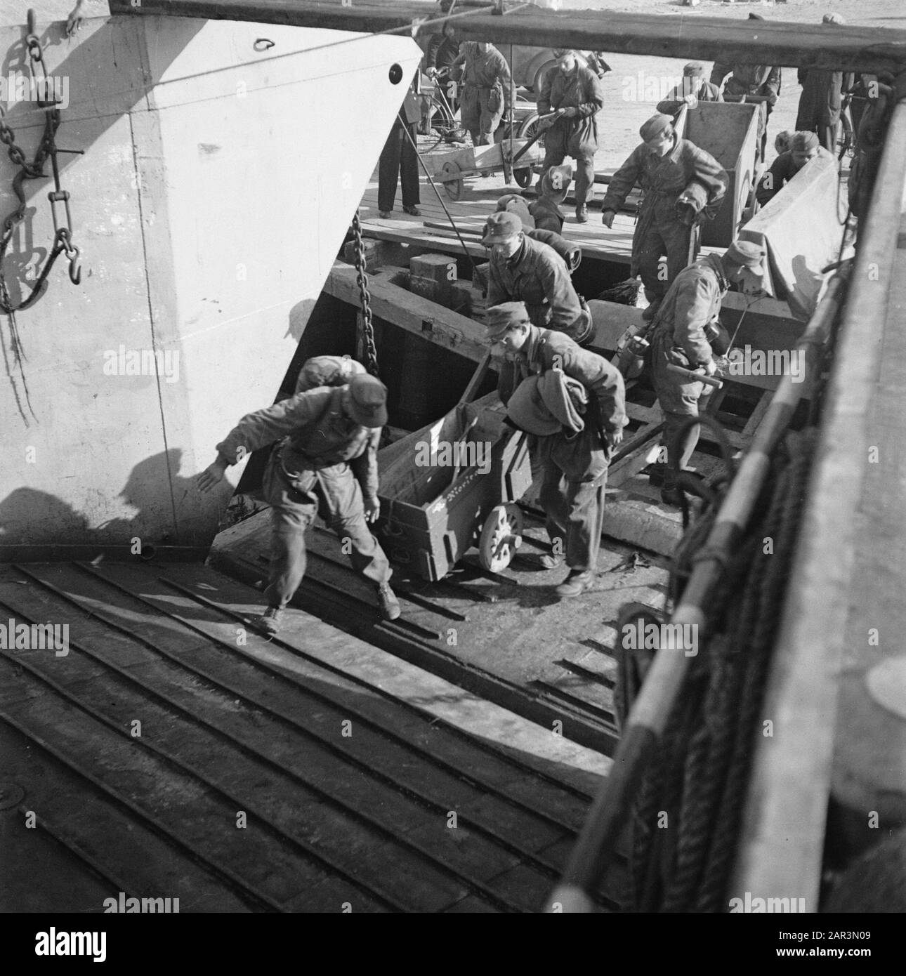 Kapitulation: Den Helder In den Helder sind die entwaffneten deutschen Soldaten in LCT-Booten nach Harlingen eingeschlagen, von wo aus die lange Reise zur Heimat zu Fuß unternommen wird. Die Transportmittel, die sie für den Transport ihres Gepäcks behalten durften, werden an Bord geschleppt Datum: Juni 1945 Ort: Den Helder Schlüsselwörter: Kriegsgefangene, Schiffe, Zweiter Weltkrieg Stockfoto