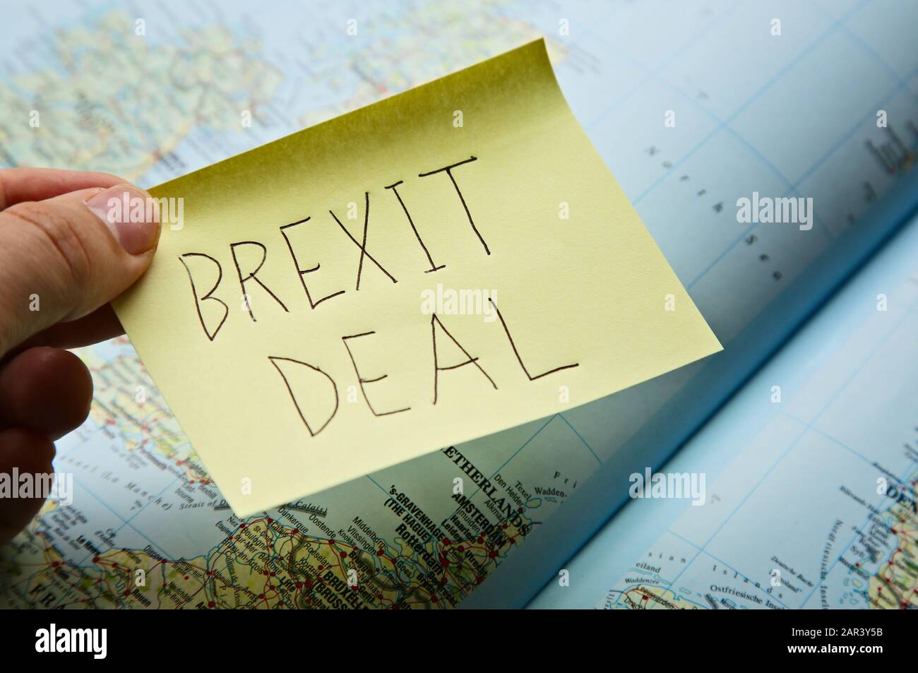 Aufnahme einer Person, die eine Haftnotiz hält "Brexit-Deal" über eine Landkarte sagen Stockfoto