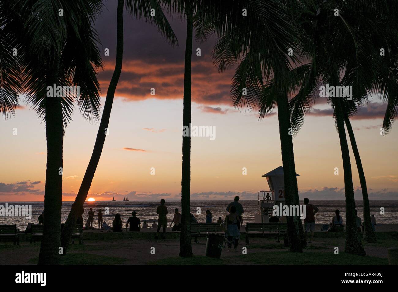 Honolulu, Hawaii, USA. Dezember 2019. Strandbesucher genießen den Sonnenuntergang am Kaimana Beach, Honolulu, Hawaii. Der Strand ist auch als Strand von Sans Souci bekannt und bei Einheimischen und Touristen beliebt. Kredit: Bayne Stanley/ZUMA Wire/Alamy Live News Stockfoto