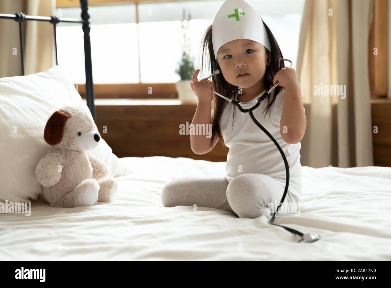 Süßes kleines asiatisches Mädchen heilen flauschiges Spielzeug zu Hause Stockfoto