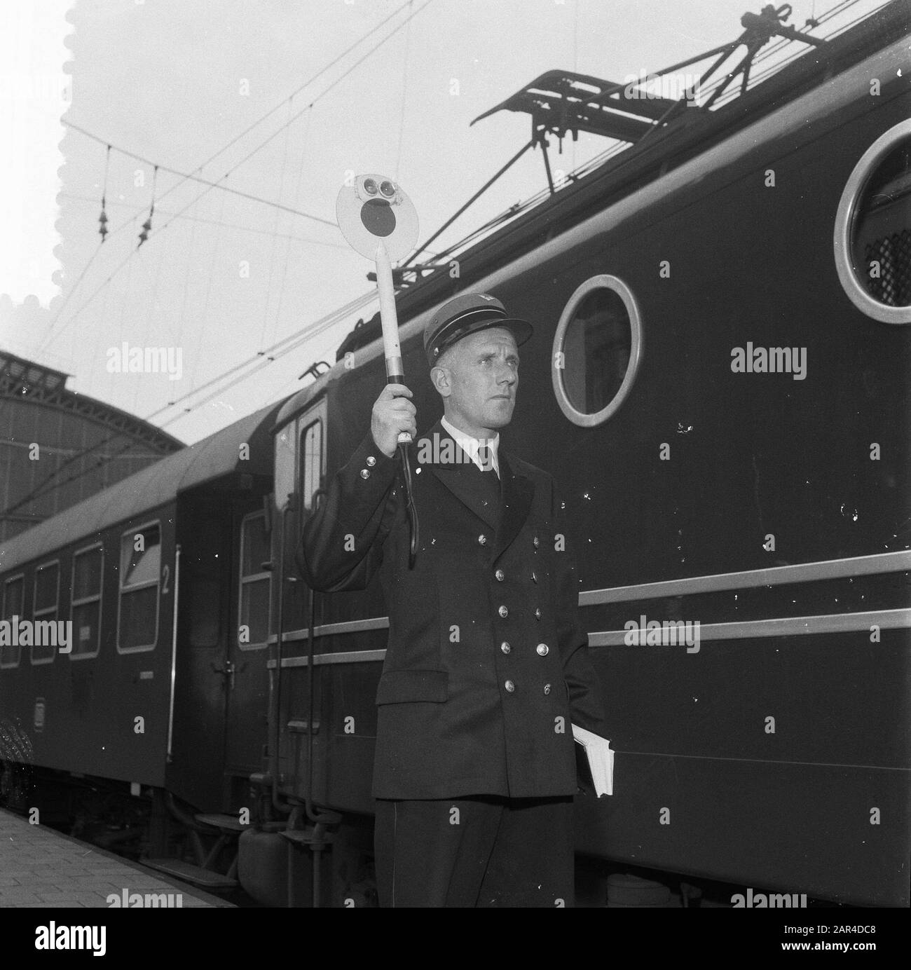 Bahnsteigchef Coppens van het Centraal Bahnhof Datum: 8. September 1957 Standort: Amsterdam, Noord-Holland Schlagwörter: Schilder, Personal, Eisenbahn, Züge Personenname: Coppens Stockfoto