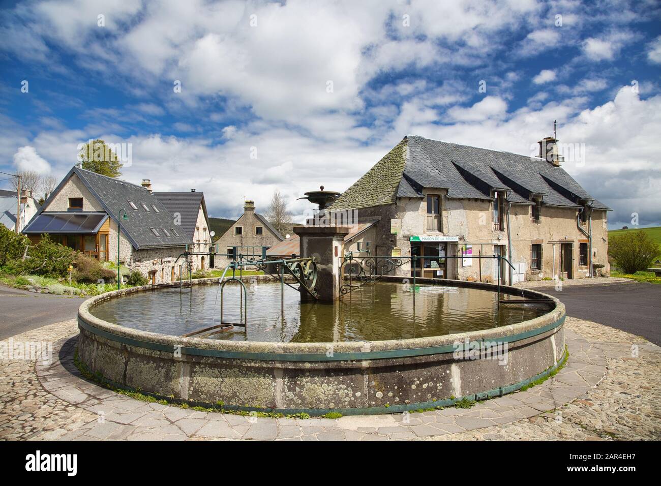 Ein runder Brunnen in La Godivelle, einem kleinen Dorf im Hochland der Auvergne, Frankreich Stockfoto