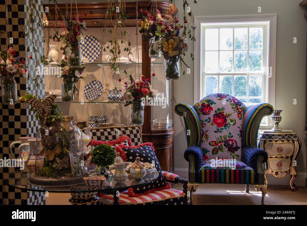 27. Juli 2019 - Aurora, NY, USA: Interieur des Mac Kenzie-Childs Shops mit Möbeln und mehrfarbigem Heimdekor, Höfliches Royal Check Emaille Geschirr Stockfoto