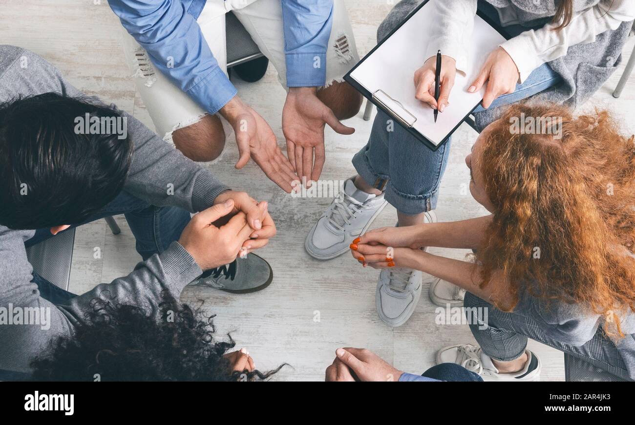 Verschiedene Menschen teilen ihre Probleme bei Gruppentherapiesitzungen, Draufsicht Stockfoto
