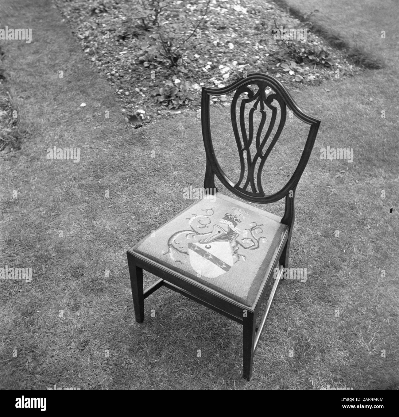 Reportage Eppo Doeve EIN Stuhl mit einem gestickten Wappen im Garten der Old Lodge in Terlow (Buckinghamshire) Datum: Juli 1954 Ort: Großbritannien Schlüsselwörter: Rasen, Stühle Stockfoto