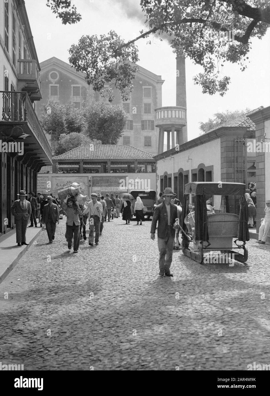 Madeira EINE Straße in Funchal auf Madeira. Im Hintergrund eine Zuckerfabrik Datum: 1934 Standort: Funchal, Madeira Schlüsselwörter: Fabriken, Stadtbilder Name Der Einrichtung: KNSM Stockfoto