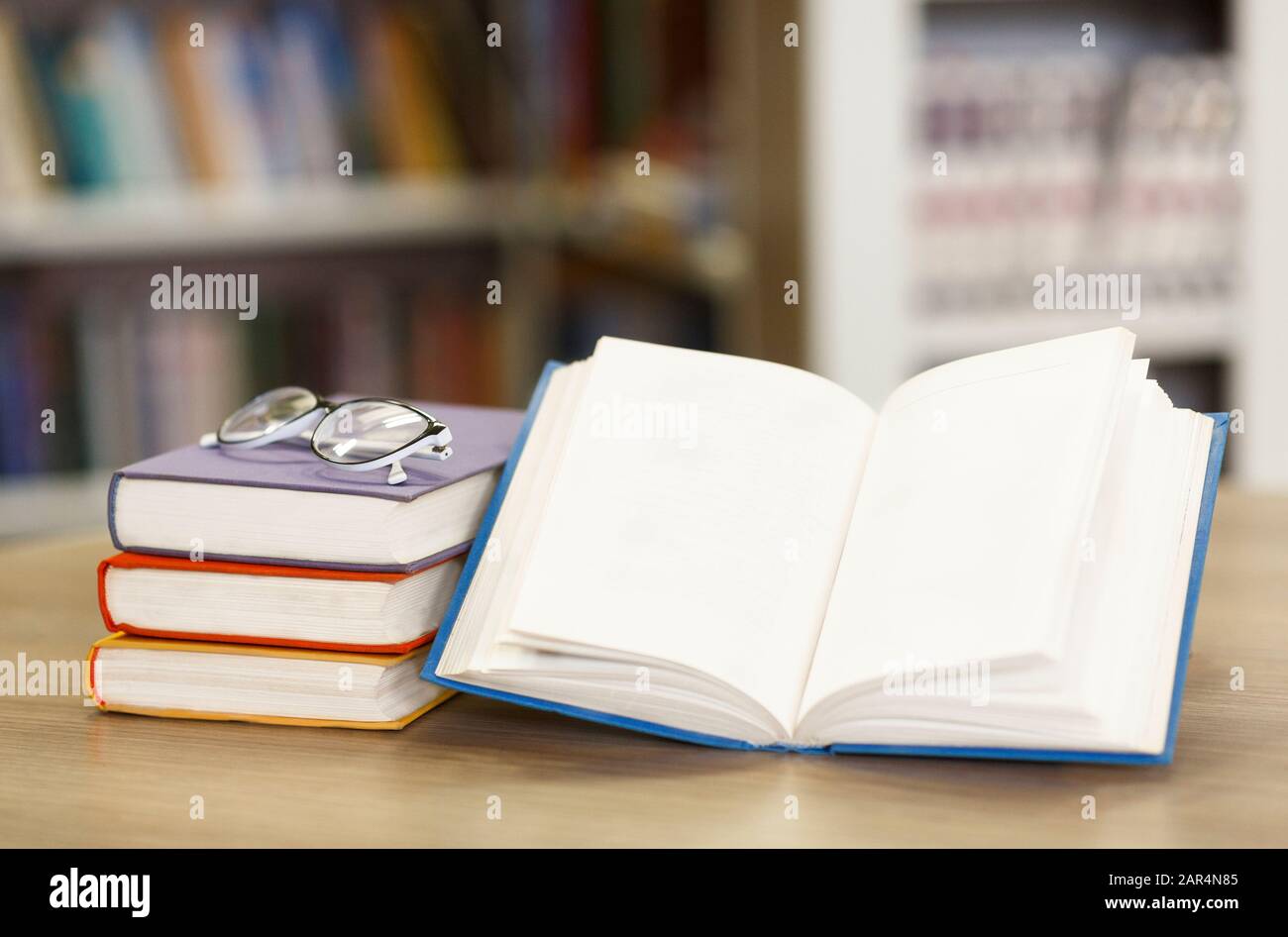 Geöffnetes Buch mit Bücherregal in der Rückseite Stockfoto