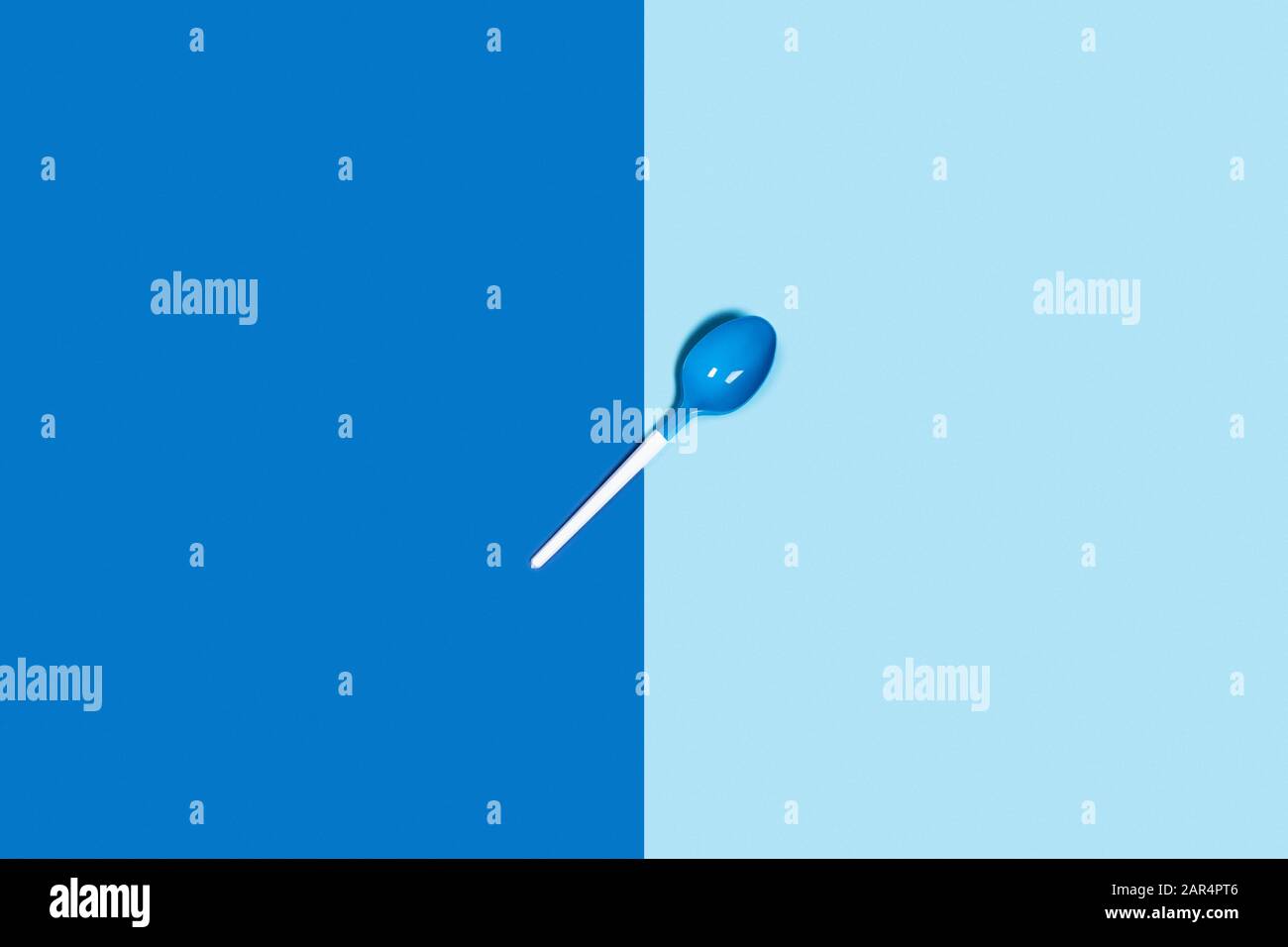Abbildung der weißen Kunststofflöffel auf blauem Hintergrund. Flache Lage, Draufsicht. Stockfoto