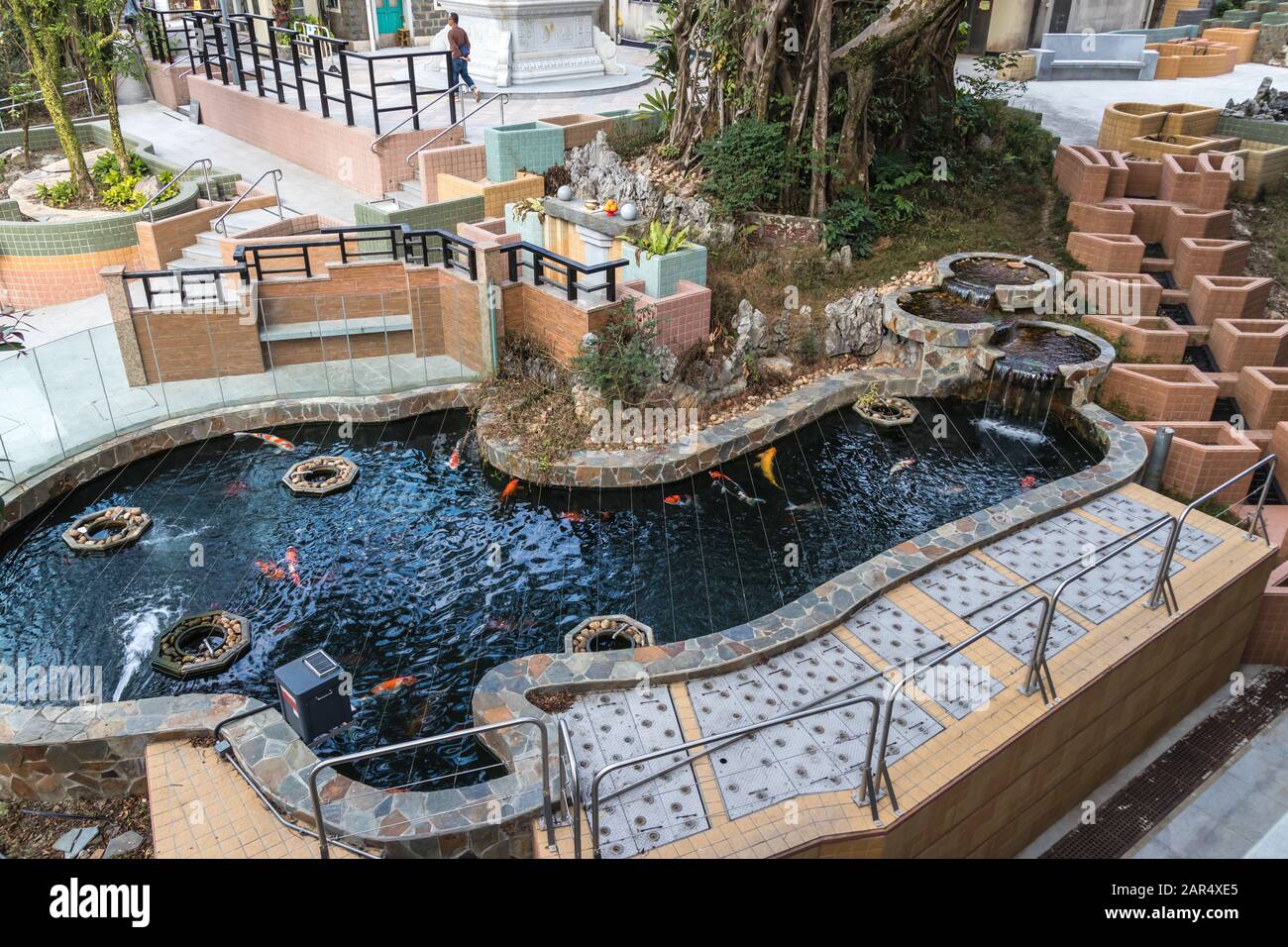 Ein Springbrunnen mit einer Kaskade und farbigen Karpfen (Jinli) im Kloster Po Lin, Insel Lantau, Hongkong Stockfoto