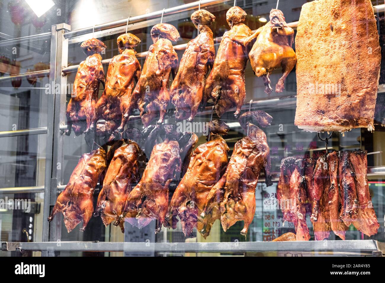 Roast-Ente und anderes gekochtes Fleisch hängen im Vorderfenster eines chinesischen Restaurants in Londons Chinatown Stockfoto