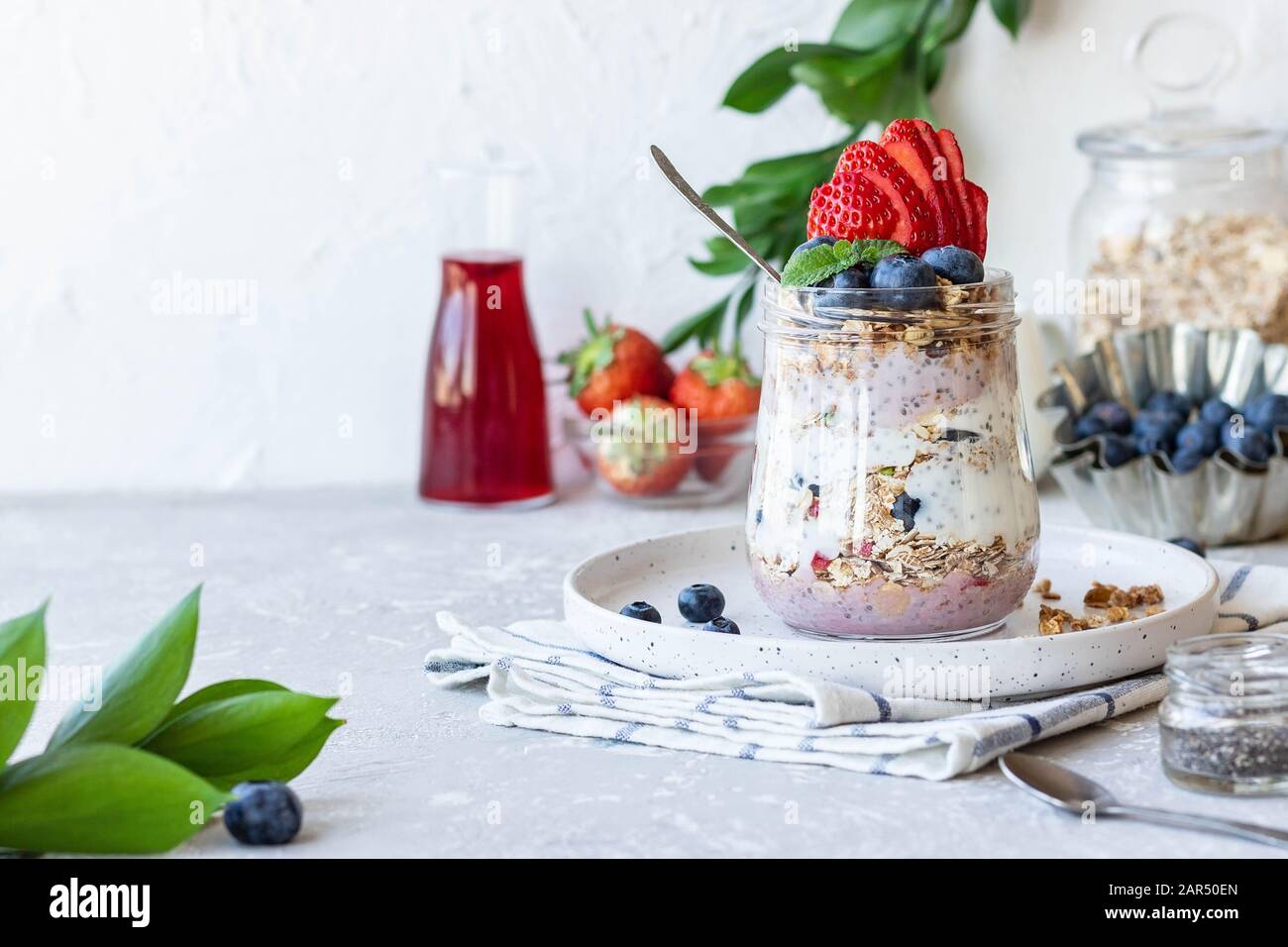 Joghurt Pudding mit chia Samen, hausgemachtem Granola und frischen Beeren in einem Glasbecher. Leichter Snack. Gesundes Frühstück. Stockfoto