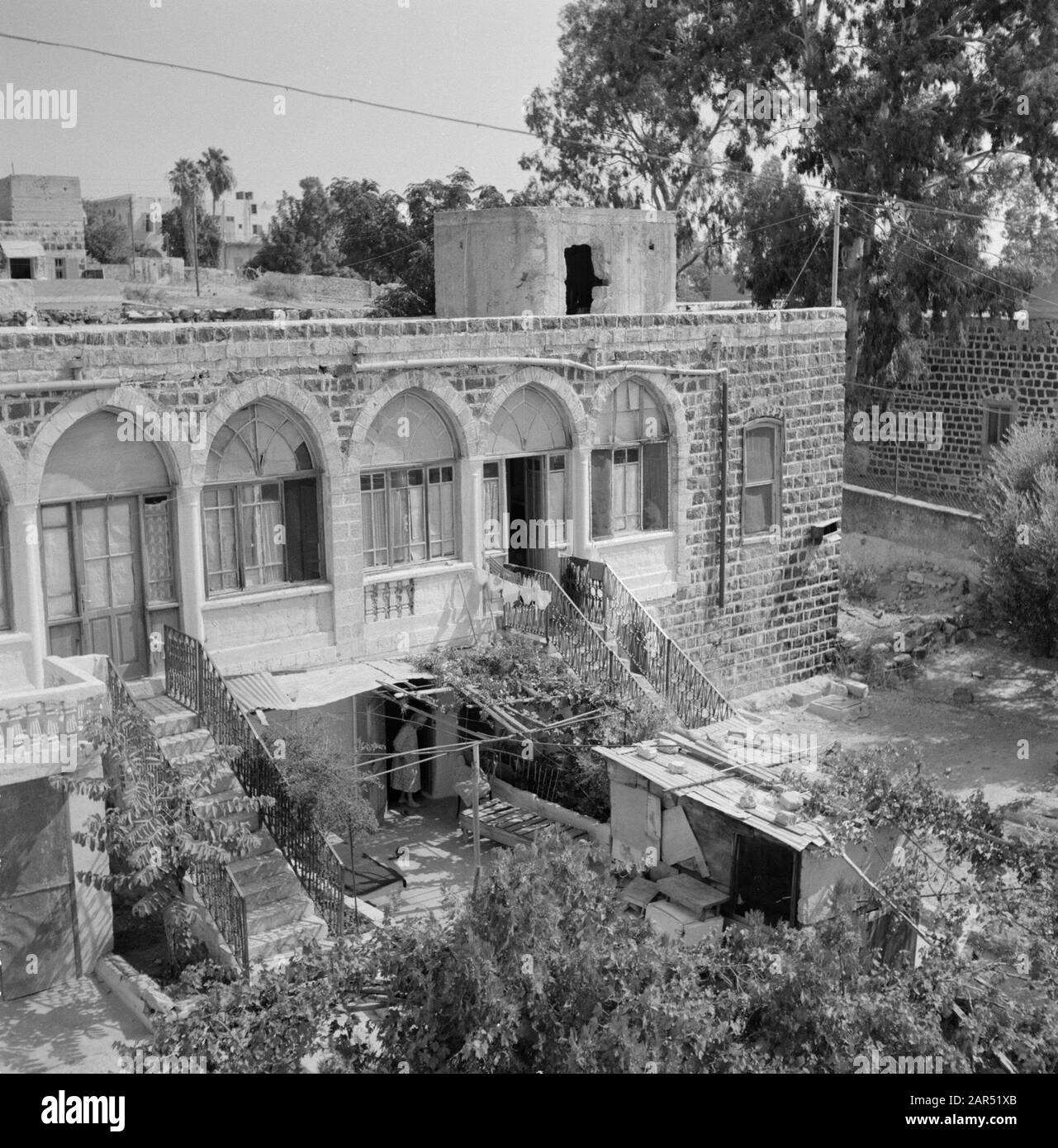 Blick auf ein Wohnhaus mit einer Etage mit arkaden. Die verschiedenen Unterkünfte auf dem Boden sind von außen über Treppen mit Metallschienen zugänglich Datum: Undatierte Lage: Israel, Tiberias Schlüsselwörter: Architektur, Metalle, Stadtansichten, Treppen, Wohnungen Stockfoto