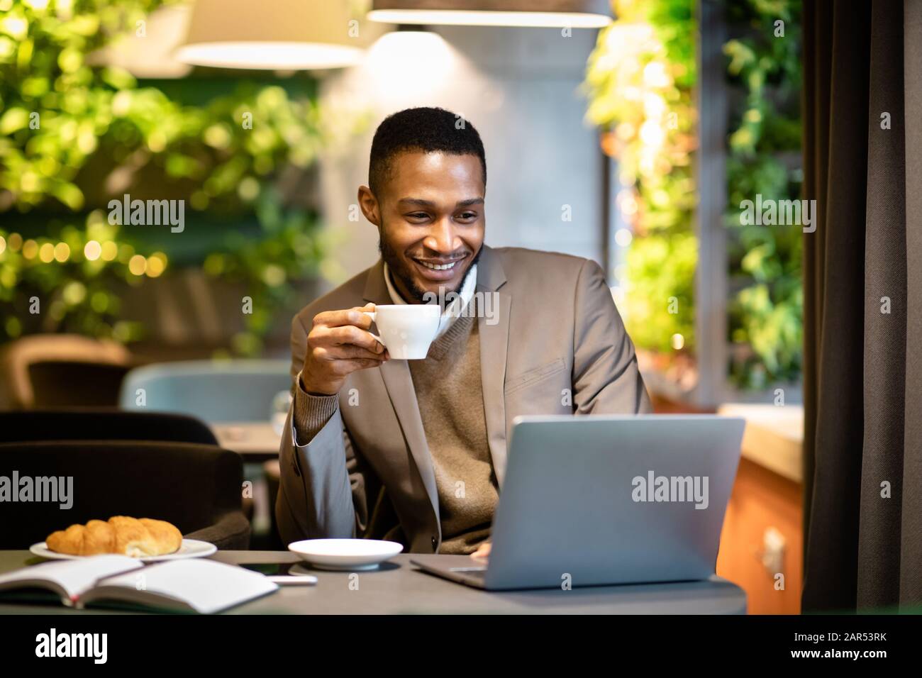 Schwarzer Kerl, der eine Tasse Kaffee im Büro hält Stockfoto