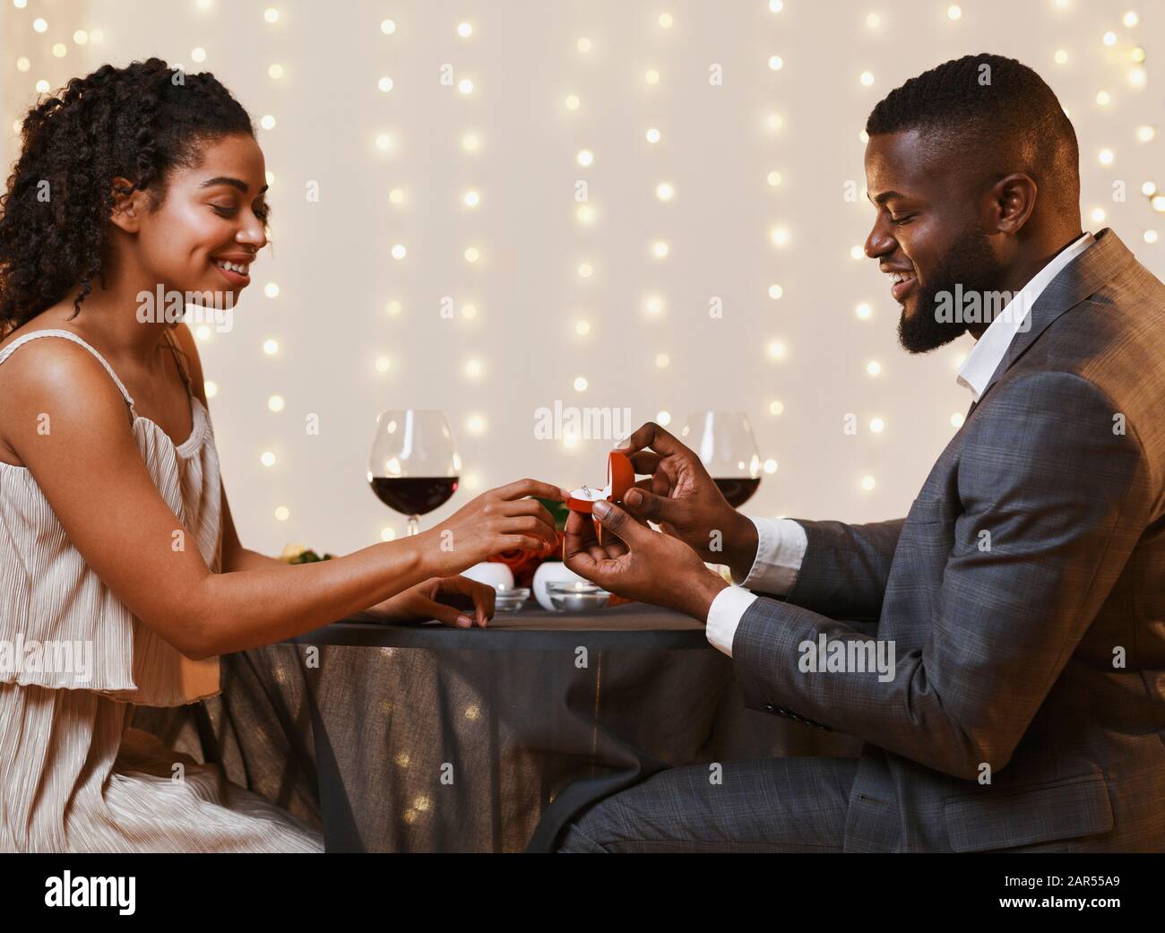 Junges schwarzes Paar, das sich im Restaurant engagiert Stockfoto