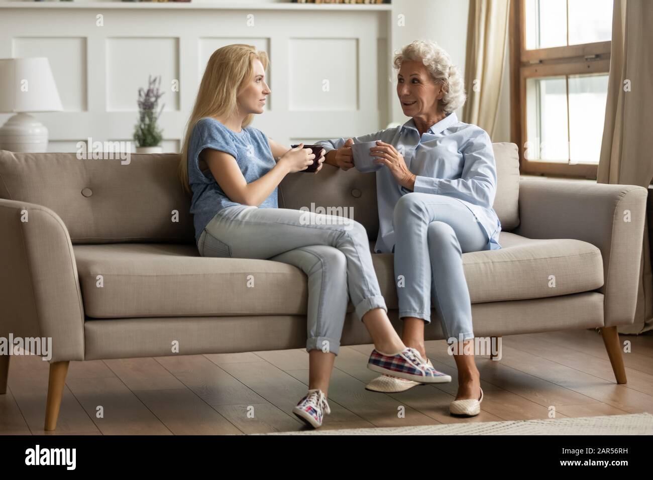 Lächelnde Mutter mittleren Alters im Gespräch mit erwachsener Tochter. Stockfoto