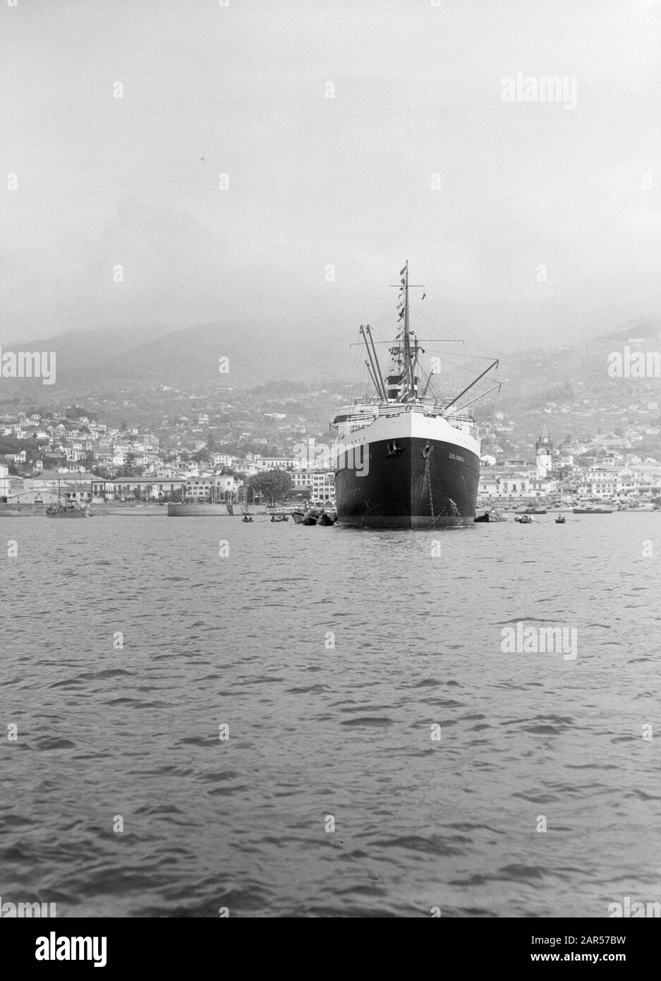 Kolumbien Das Kreuzfahrtschiff MS Kolumbien der K.N.S.M. im Hafen von Funchal mit der Stadt und den Bergen im Hintergrund. Madeira Datum: 1934 Ort: Funchal, Madeira, Portugal Schlüsselwörter: Häfen, Schiffe Name Der Einrichtung: Kolumbien, KNSM Stockfoto