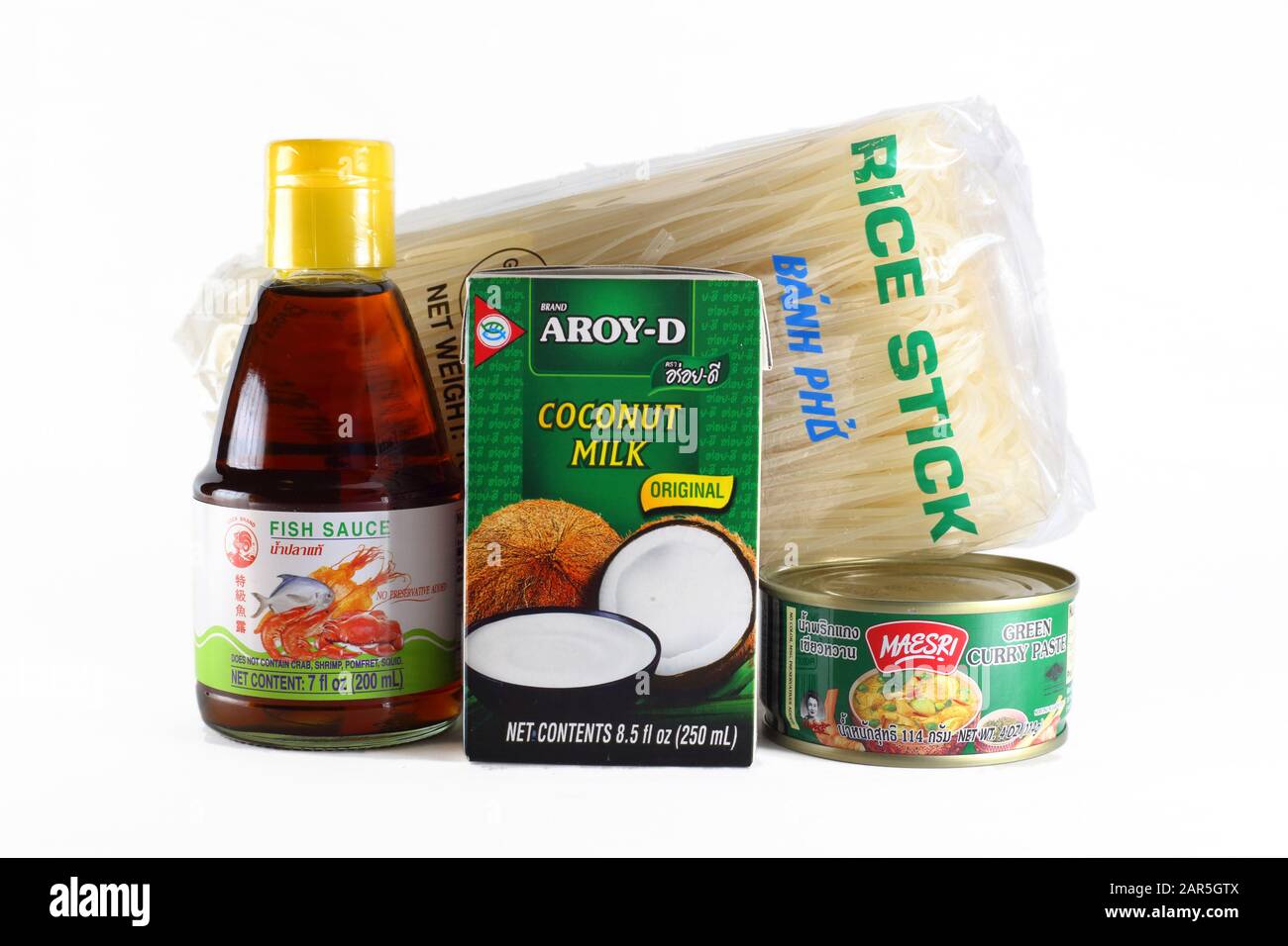 Thailändische Zutaten, grüne Currypaste, Reisnudeln, Kokosmilch, Fischsauce isoliert auf weißem Hintergrund. Ausschnitt für redaktionelle Verwendung Stockfoto