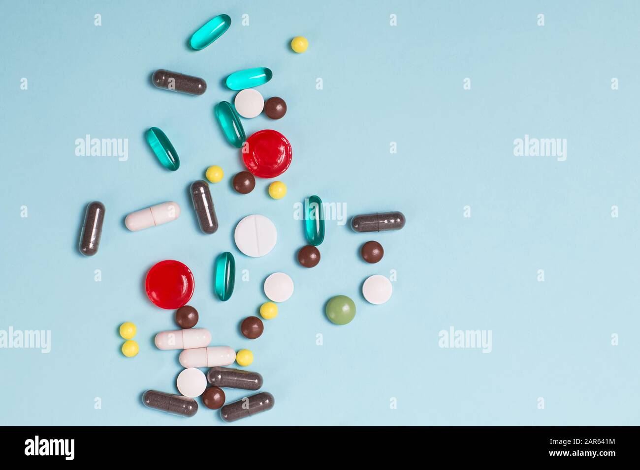 Verschiedene mehrfarbige Pillen und Tabletten auf blauem Hintergrund. Stockfoto
