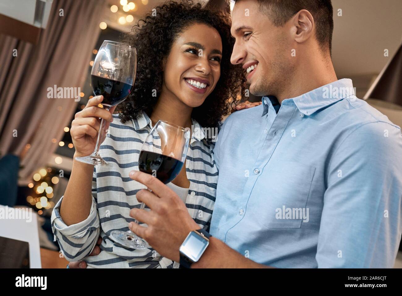 Junges multikulturelles Paar, das Wein trinkt und gemeinsam Abend verbringt Stockfoto