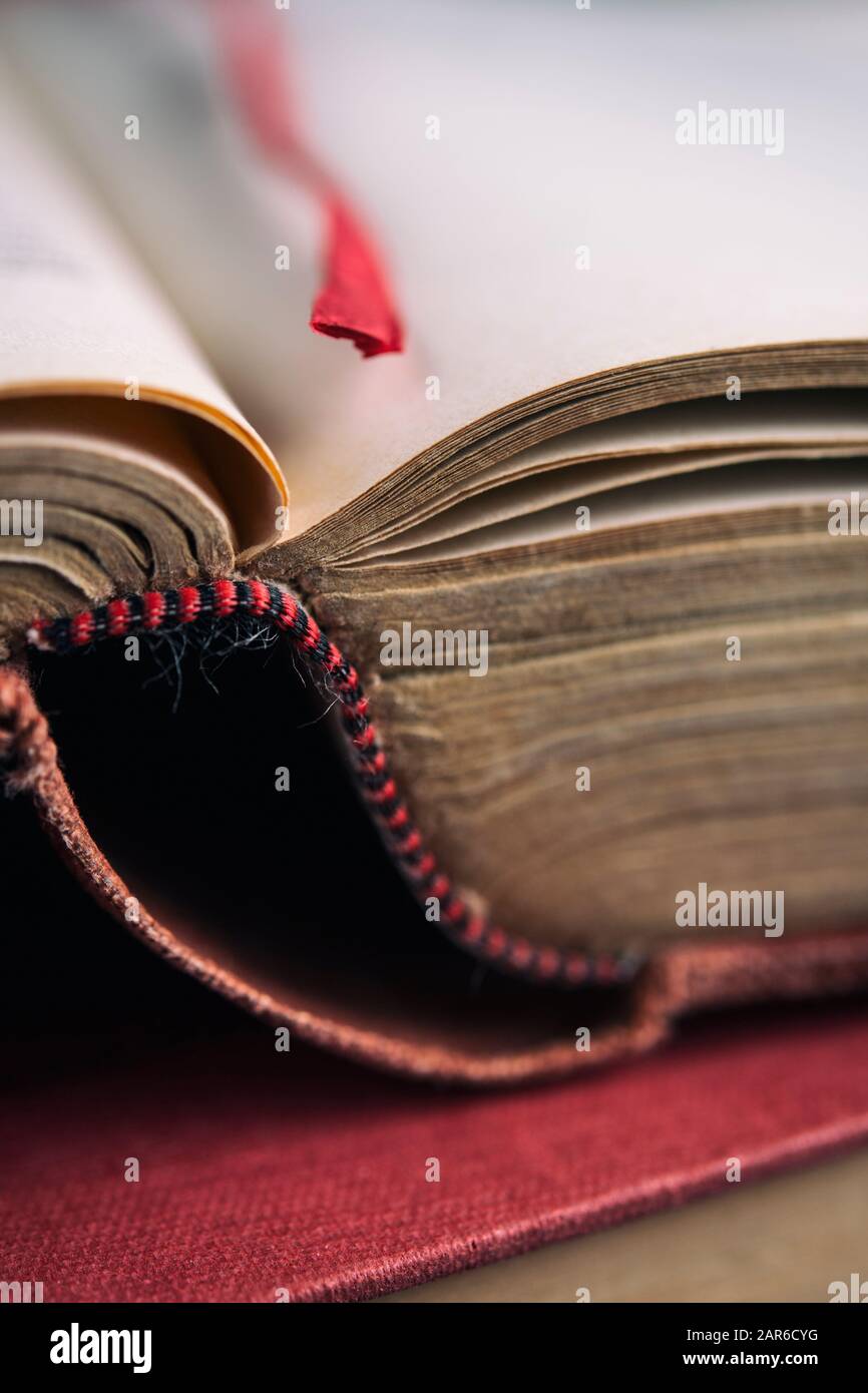 Antikbuch auf einer Seite mit einem roten Bandlesezeichen geöffnet Stockfoto