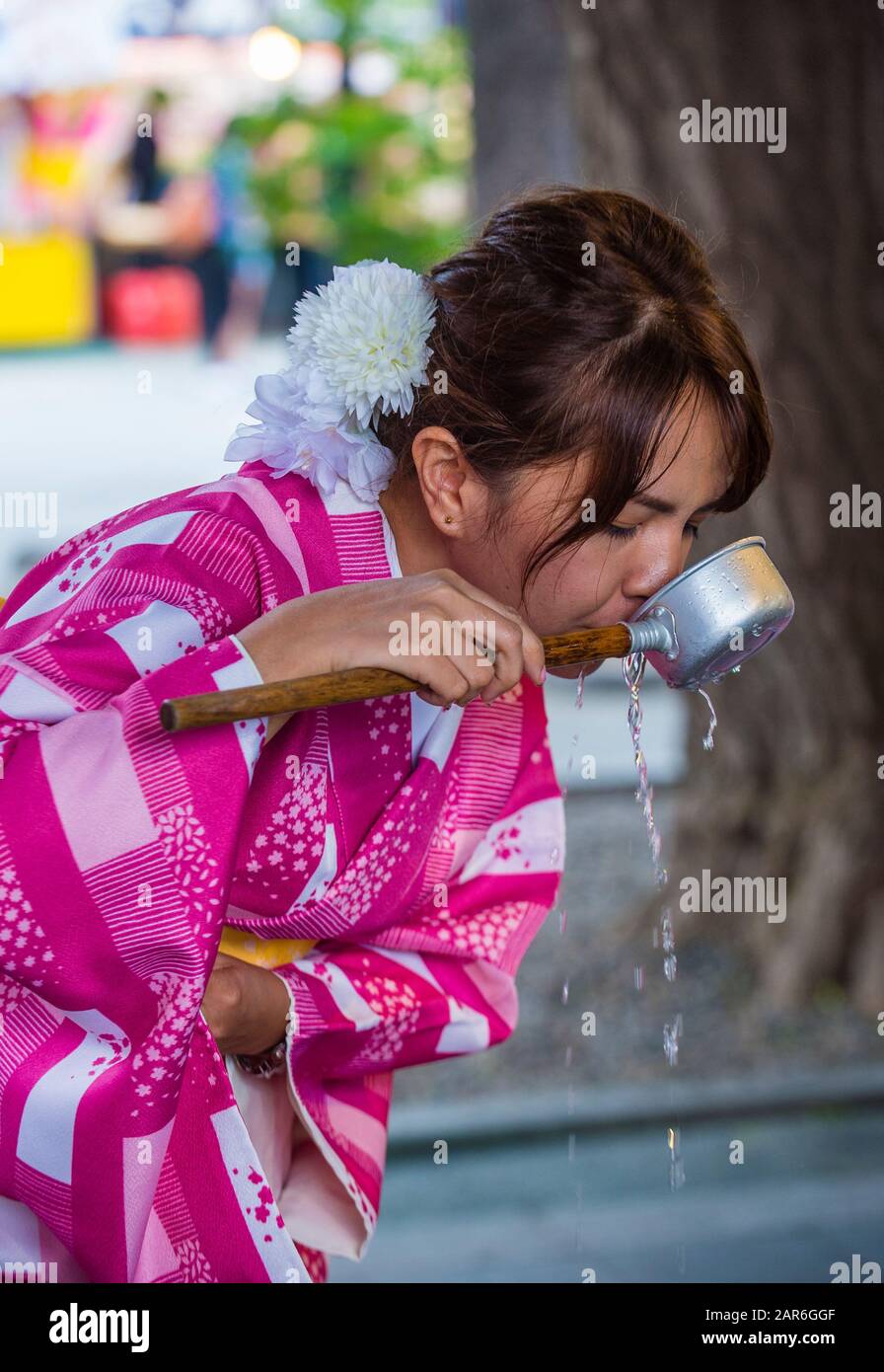 Japanische Frau, die Wasser in einem Chozuya in einem Schrein in Tokio trinkt Japan Stockfoto
