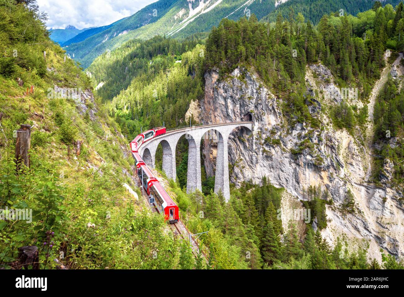 Landwasser-Viadukt in Filisur, Schweiz. Es ist ein berühmtes Wahrzeichen der Schweizer. Berglandschaft mit rotem Bernina-Express auf hoher Brücke. Sceni Stockfoto