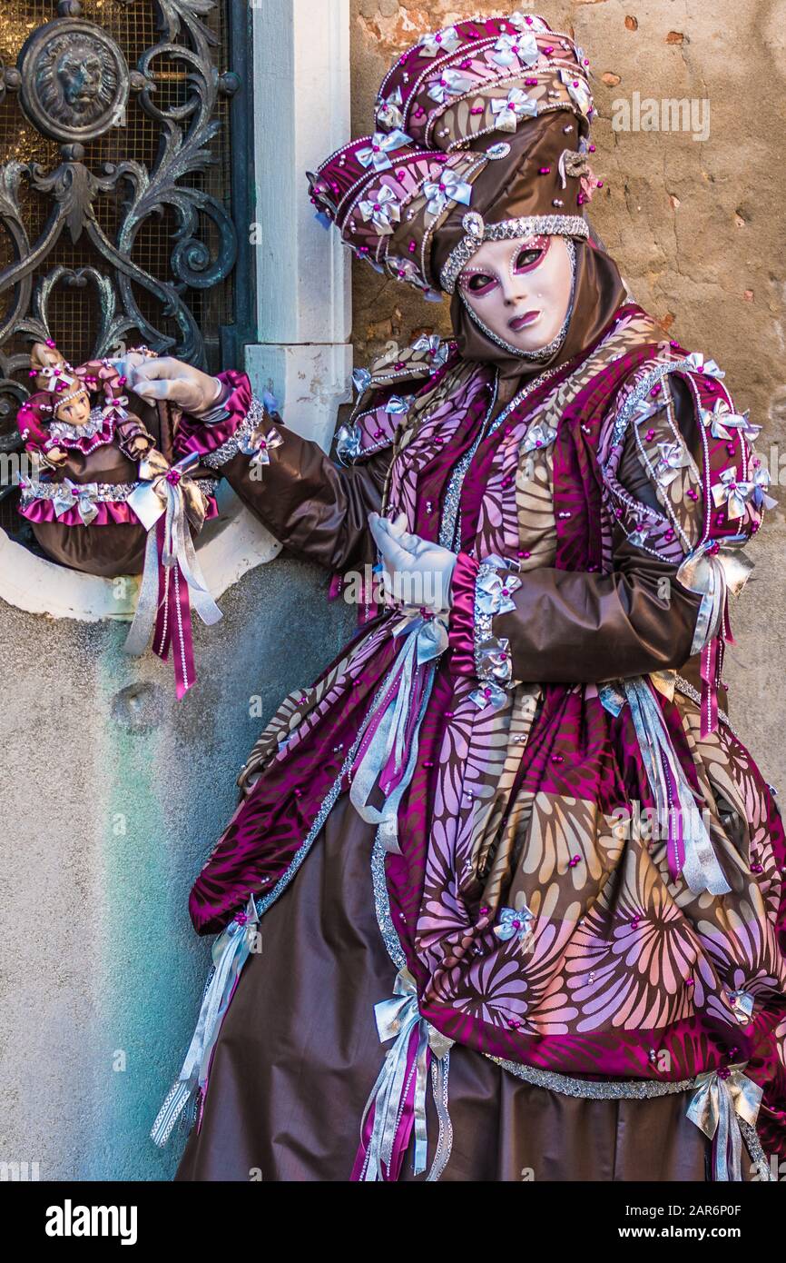 Fantasievolle Maske in prächtiger Tracht beim Karneval in Venedig. Die Menschen dahinter sind nicht mehr erkennbar und feiern den traditionellen Karneval von Stockfoto