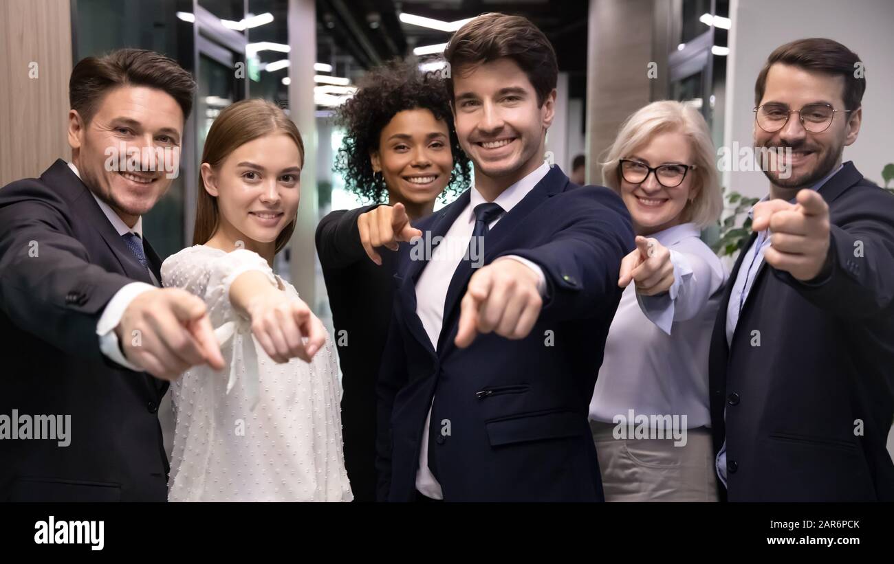 Glückliche, unterschiedliche Altersgruppen, multirassische Geschäftsleute, die mit den Fingern auf die Kamera zeigen. Stockfoto