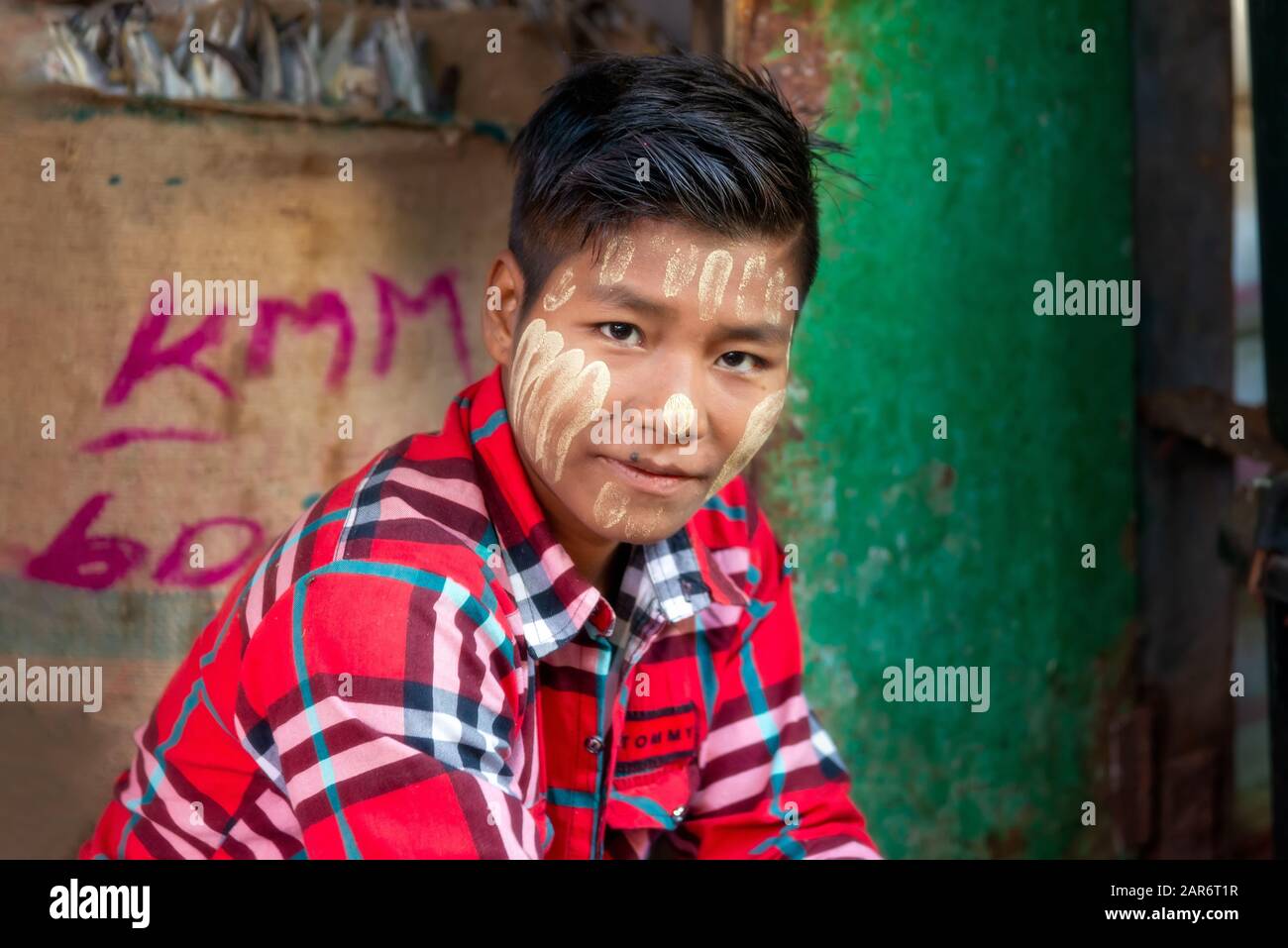 Pakokku, Myanmar - 22. Dezember 2019: Teenager mit Thanaka-Paste auf seinem Gesicht auf dem Myommarkt. Thanaka ist eine gelbweiße kosmetische Paste Stockfoto