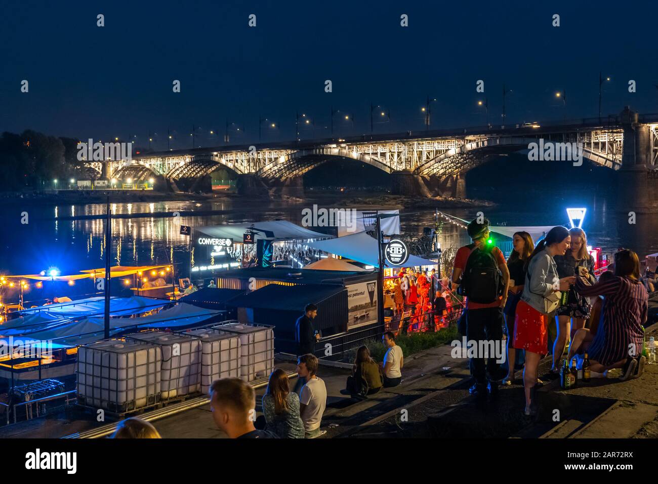 Die Jugendlichen entspannen nachts am Weichselufer in der Nähe der Poniatowski-Brücke in der Stadt Warschau in Polen Stockfoto