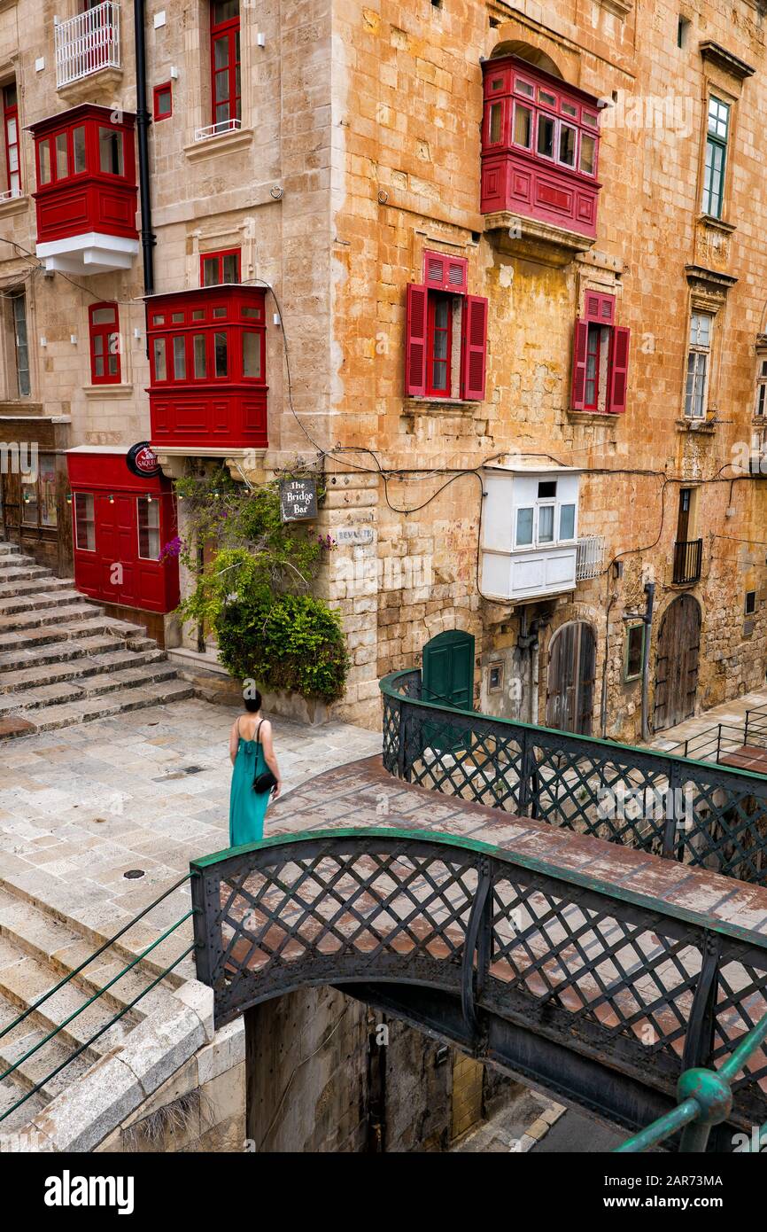 Altstadt von Valletta auf Malta, traditionelle Häuser mit Balkon, Fußgängerbrücke über die Liesse Straße und die Bridge Bar an der Ecke. Stockfoto