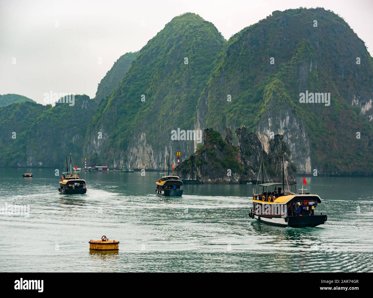 Traditionelle Boote mit Kalksteinkarstfelsen im Nebel, Lan ha Bay, Vietnam, Asien Stockfoto