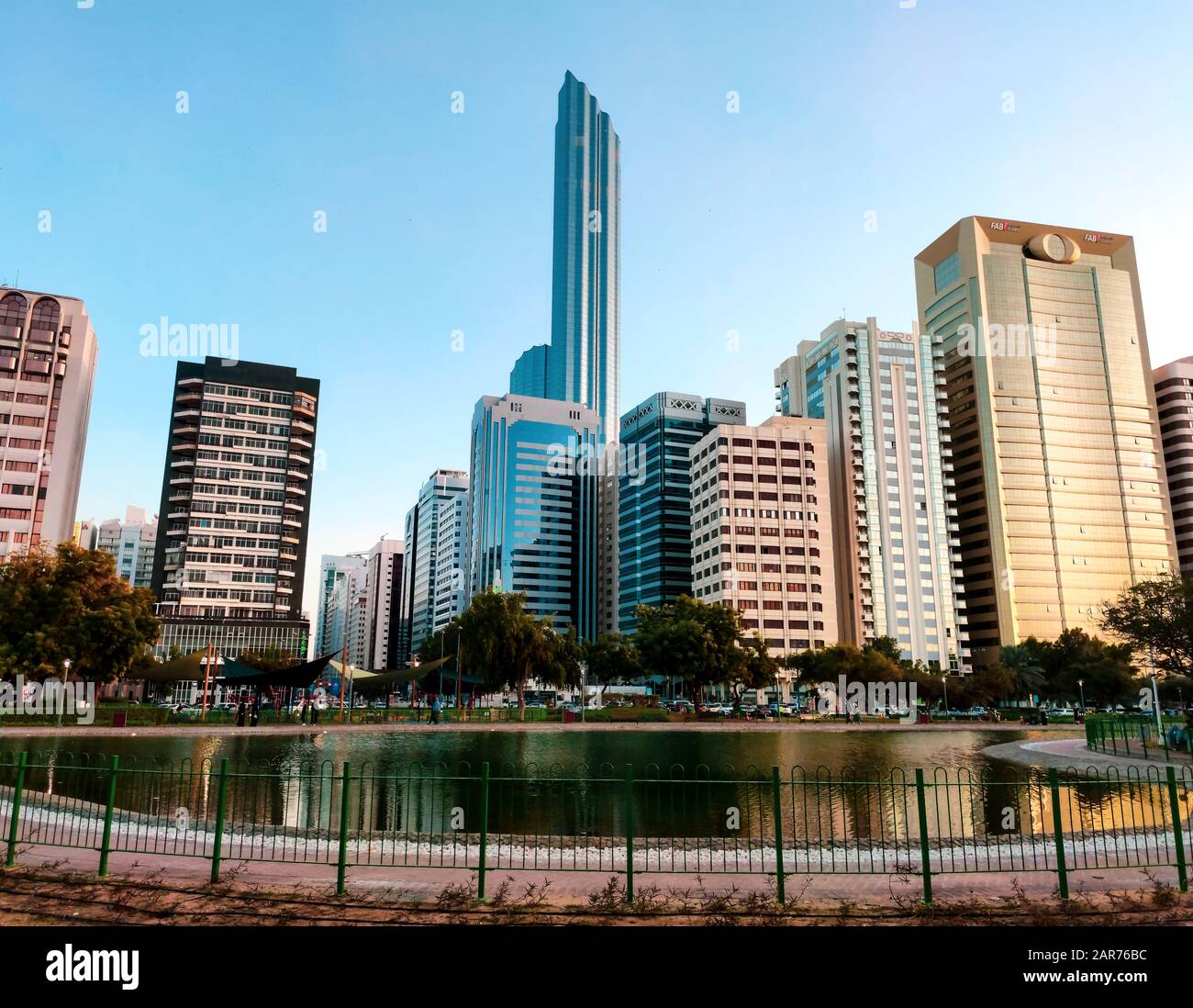 Das Stadtbild der Innenstadt von Abu Dhabi spiegelt sich im Wasser des Lake Park wider Stockfoto