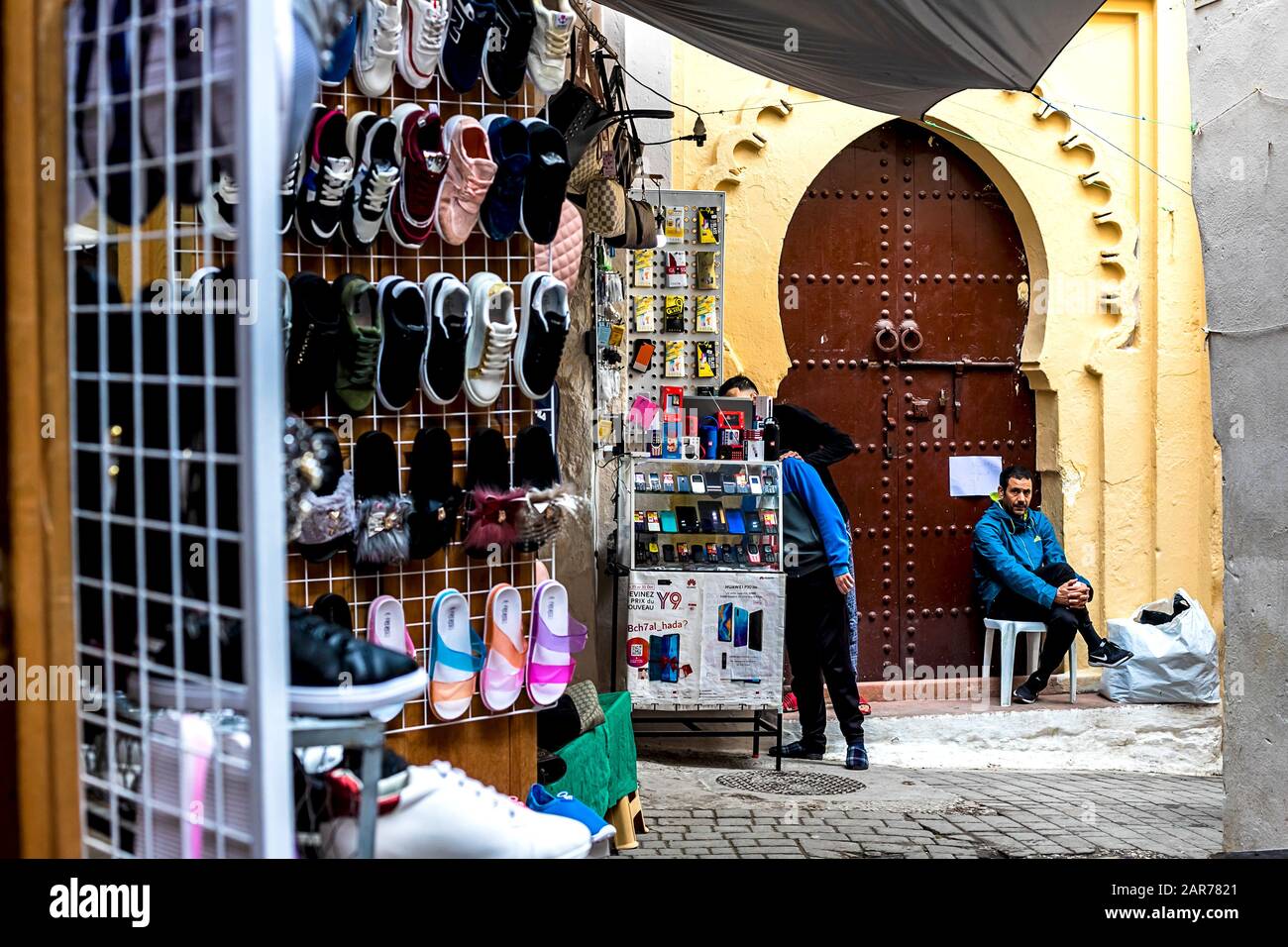 Fes, Marokko - 21.04.2019: Menschen, die in der Straße des Open-Air-Marktbasars in Fez spazieren. Traditionelle nordafrikanische Geschäfte mit handgefertigter Betubung Stockfoto