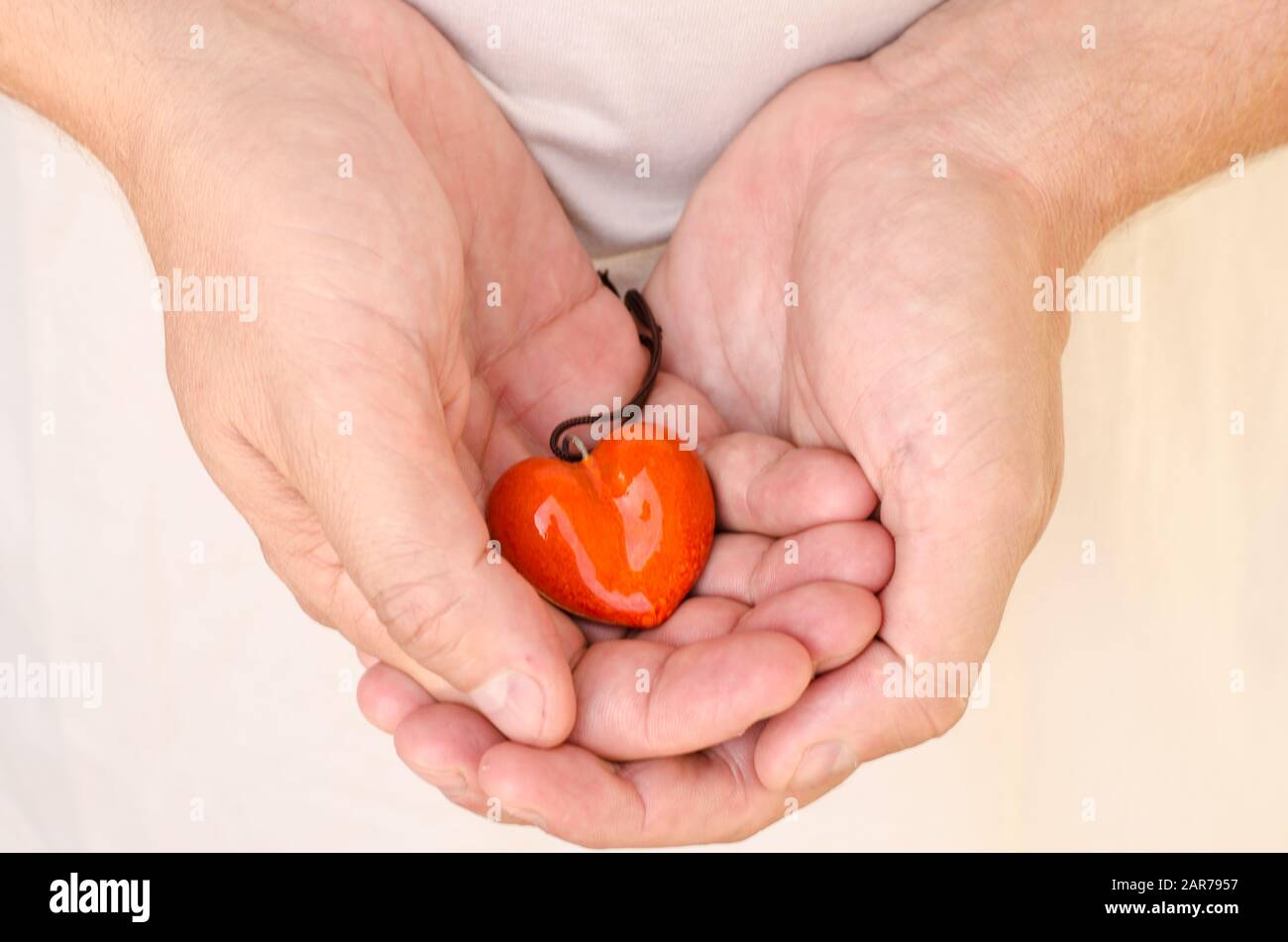Detail des weißen Herzens in den Händen Stockfoto