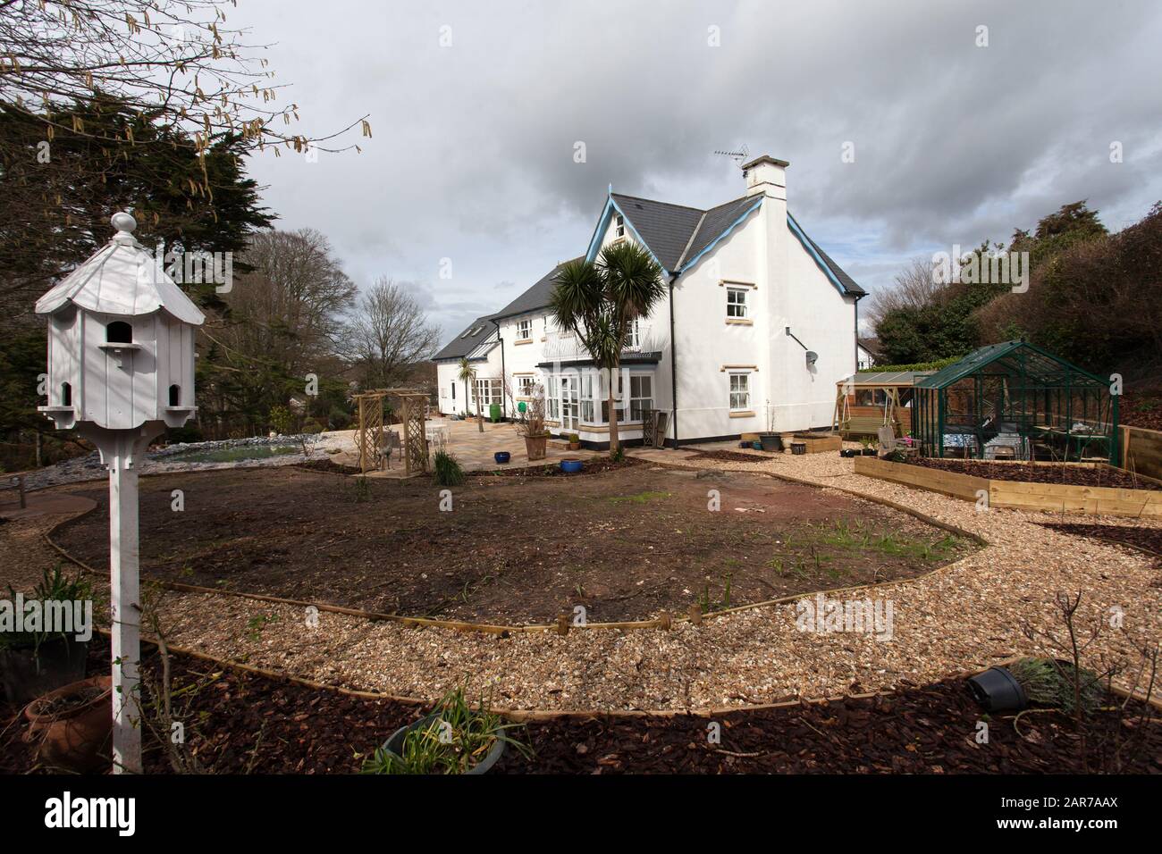 Ein Garten im Winter im Bau, Wege, Rasen, Ränder, Bogen, Schwalbenkote, Gewächshaus, bereit für die Bepflanzung. Stockfoto