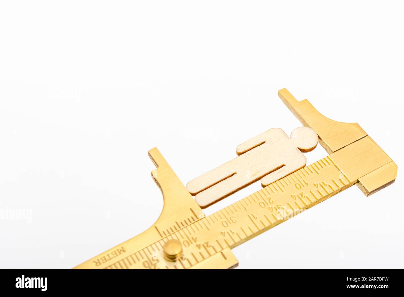 Makro kleine lasergeschnittene Holzfigur und Messing-Zirkel gegen den weißlichen BG. Messung von persönlichen Leistungsindikatoren, demografischen Daten, Produktivität, Stockfoto