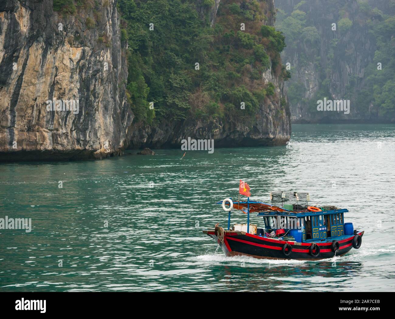 Traditionelles vietnamesisches Fischerboot und Kalkfelskarstklippen, Halong Bay, Vietnam, Asien Stockfoto