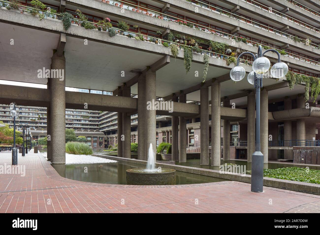 Innenhof mit Wasserflächen und Durchfahrtswegen. Barbican Estate, London, Großbritannien. Architekt: Chamberlin, Powell und Bon, 1969. Stockfoto