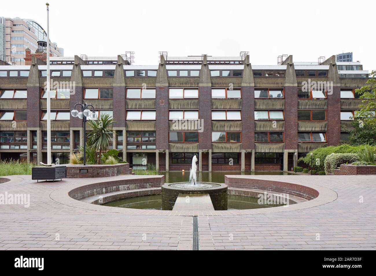 Innenhof mit Wasserflächen und gegenüberliegenden Mehrfamilienterrassen. Barbican Estate, London, Großbritannien. Architekt: Chamberlin, Powell und Bon, 1969. Stockfoto