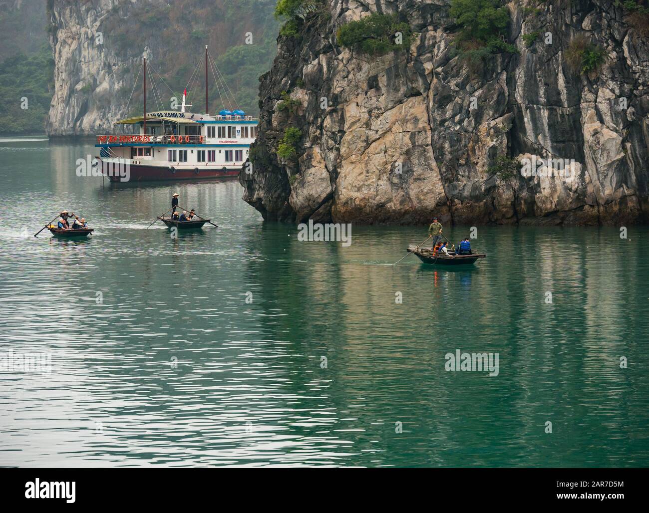 Touristen in traditionellen Korakeln und Touristenboot, Lan ha Bay, Vietnam, Asien Stockfoto
