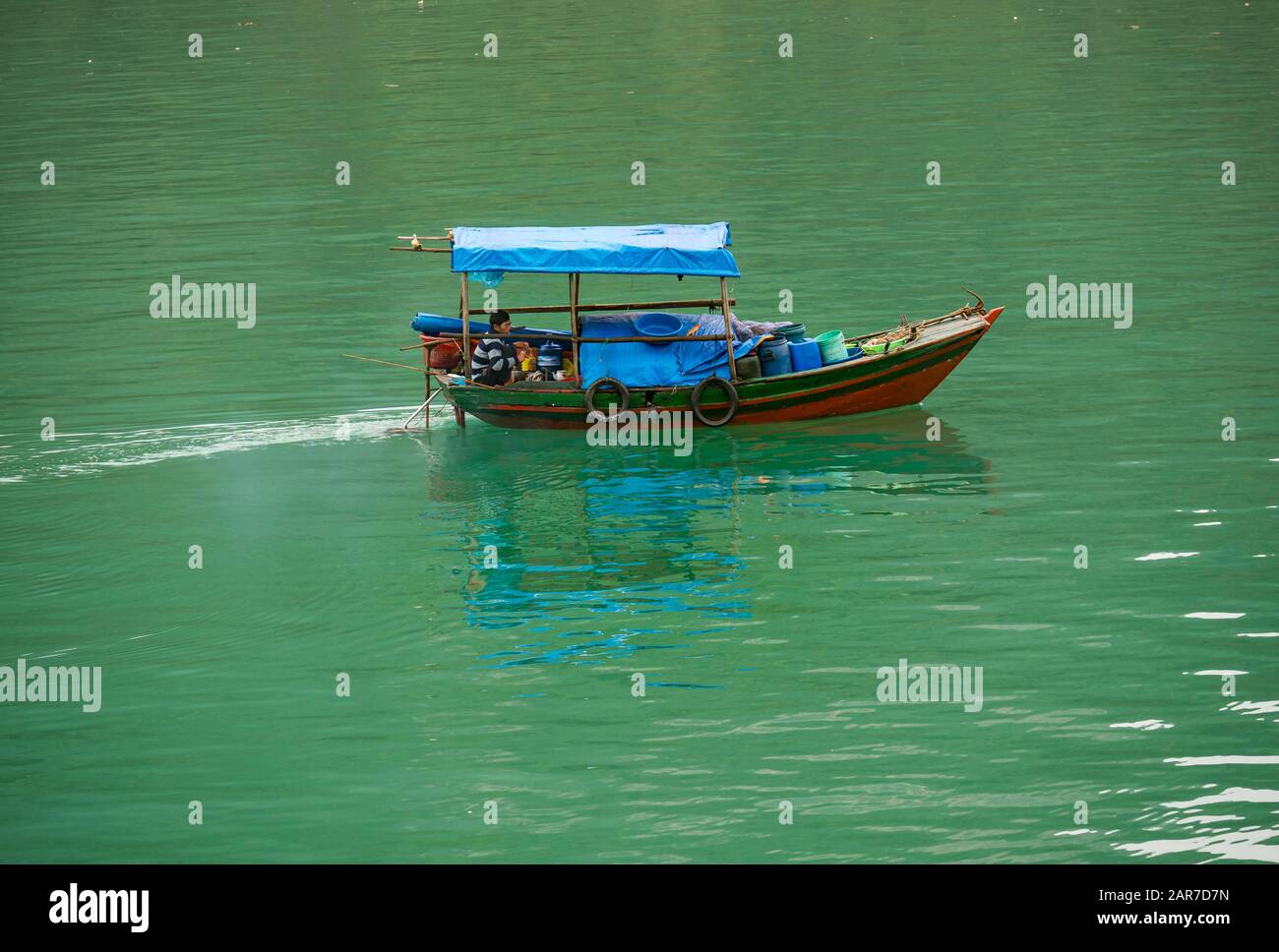 Asiatischer Mann im traditionellen vietnamesischen Fischerboot, Halong Bay, Vietnam, Asien Stockfoto