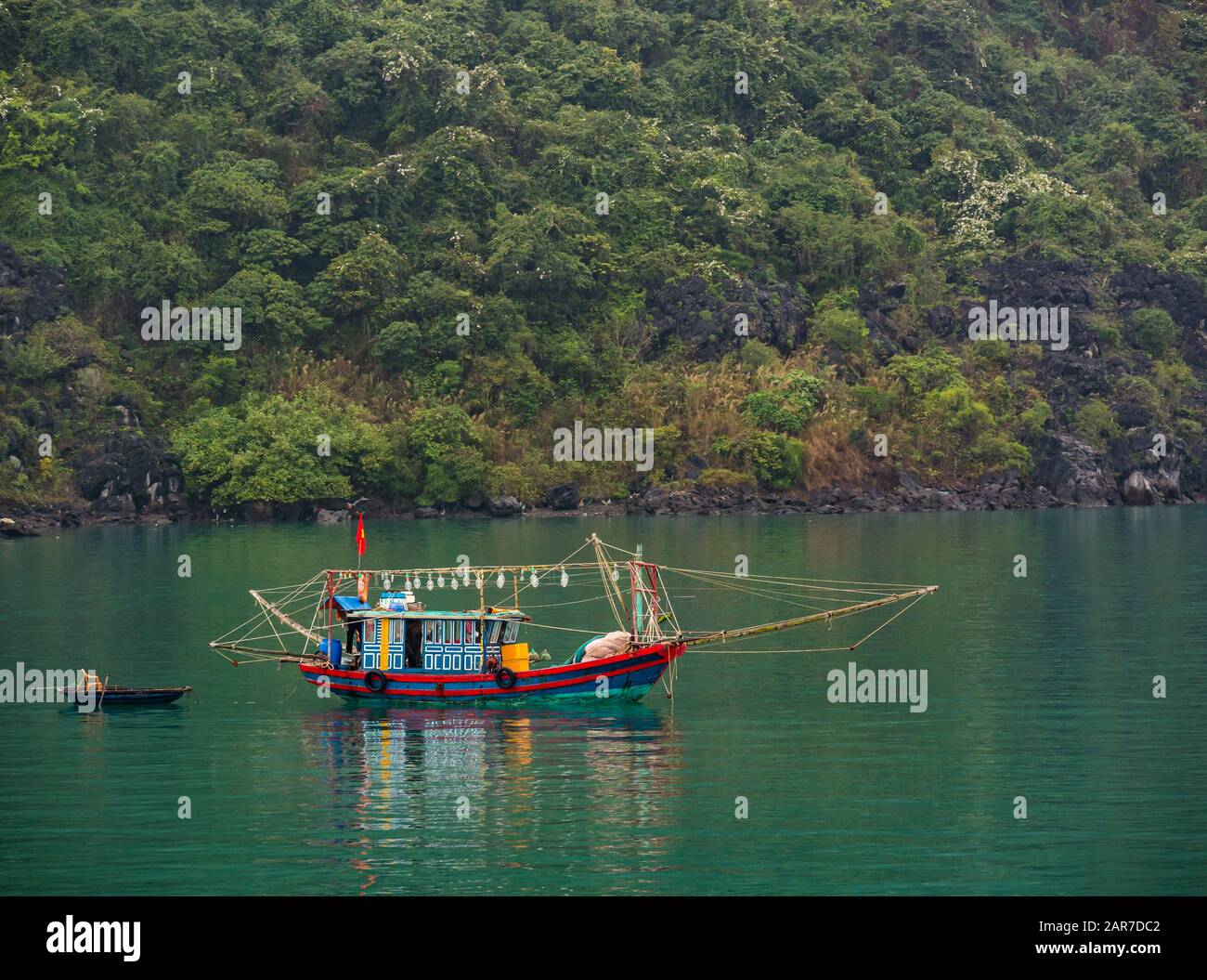 Traditionelles Fischerboot und Korakel mit Küstenlinie, Halong Bay, Vietnam, Asien Stockfoto