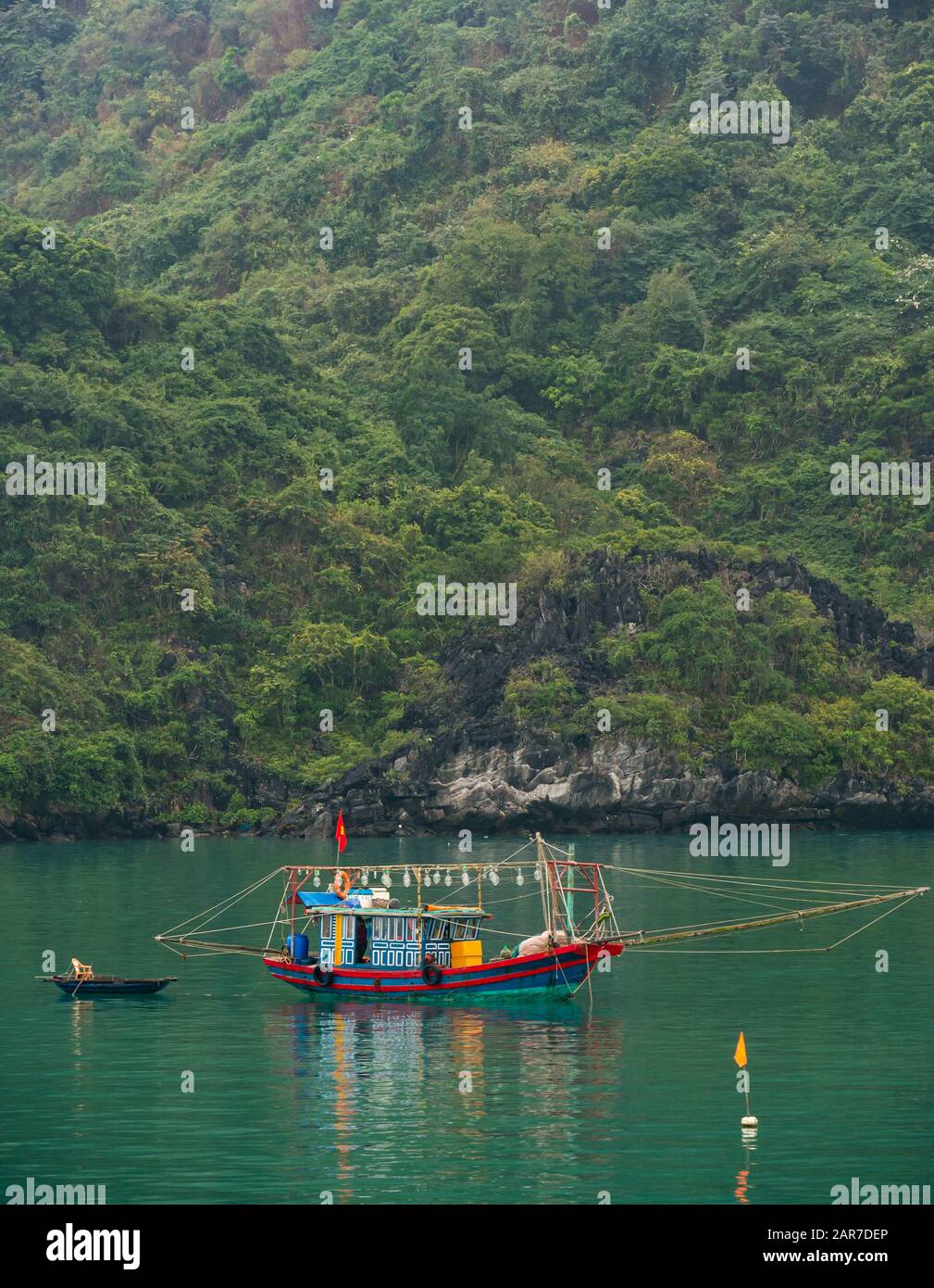 Traditionelles Fischerboot und Korakel mit Küstenlinie, Halong Bay, Vietnam, Asien Stockfoto
