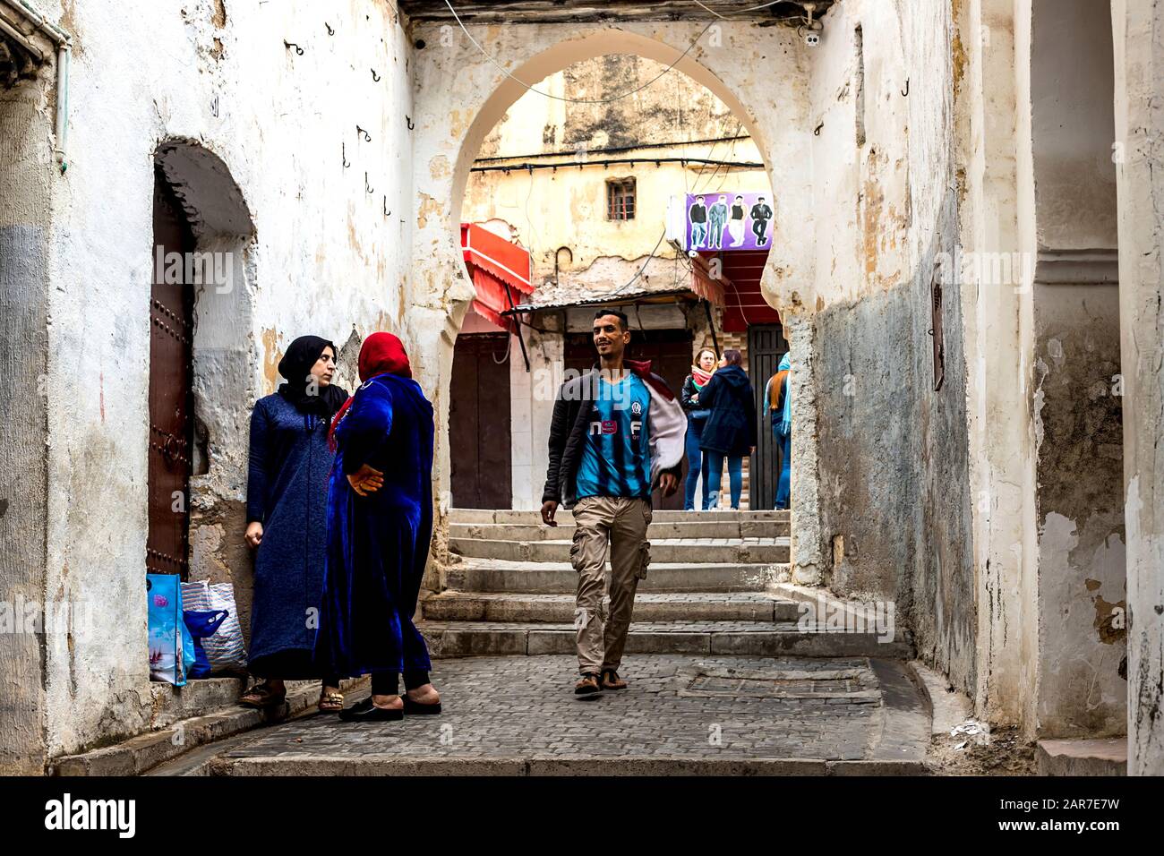 Fes, Marokko - 21.04.2019: Menschen, die in der Straße des Open-Air-Marktbasars in Fez spazieren. Traditionelle nordafrikanische Geschäfte mit handgefertigter Betubung Stockfoto