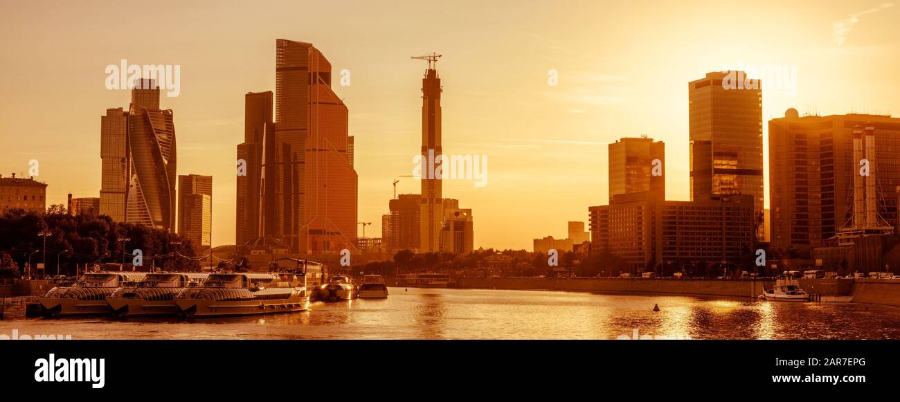 Panoramablick auf Moskau bei Sonnenuntergang, Russland. Das sonnige Moskauer Stadtbild mit dem Moskwa-Fluss im Sommer. Moderne Wolkenkratzer an der Moskauer Küste. Landschaft o Stockfoto