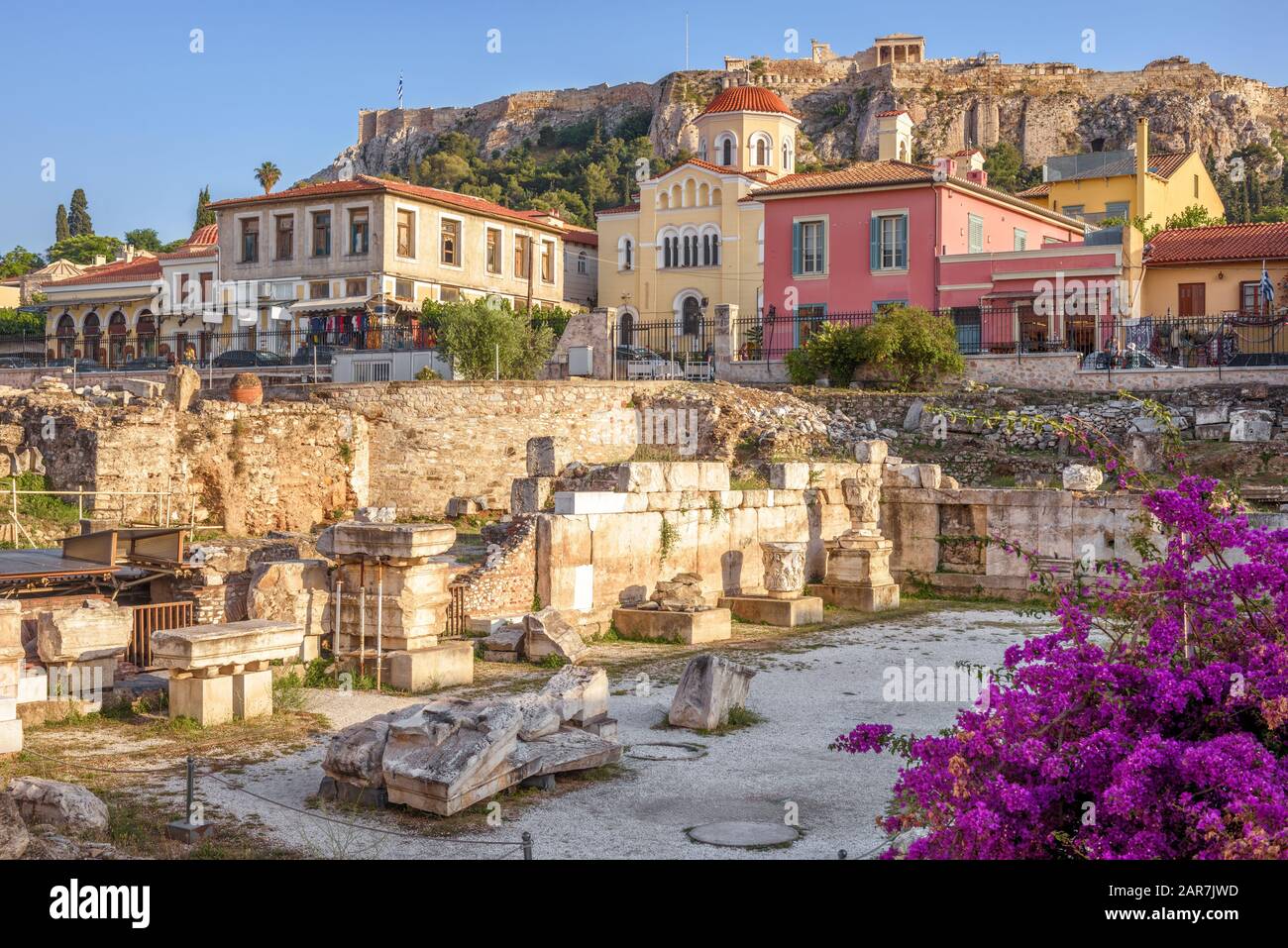 Bibliothek von Hadrian mit Blick auf alte Häuser und Akropolis, Athen, Griechenland. Schöner Blick auf die Sehenswürdigkeiten Athens. Antike griechische Ruinen in Stockfoto