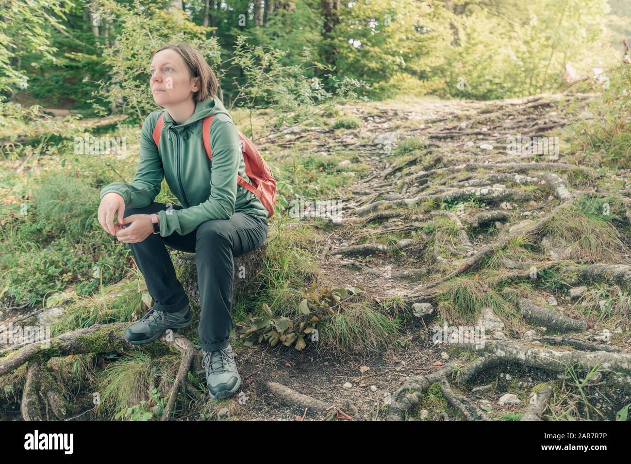 Weibliche Wanderer, die sich im Wald ausruhen und betrachten, machen eine Pause vom Wandern im Freien in den Wäldern Stockfoto