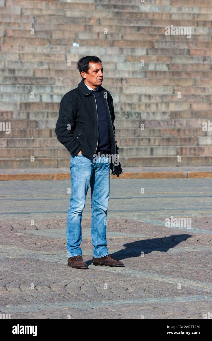 Männlicher Tourist mittleren Alters, der auf dem Senatsplatz in Helsinki, Finnland, für die Kamera posiert Stockfoto