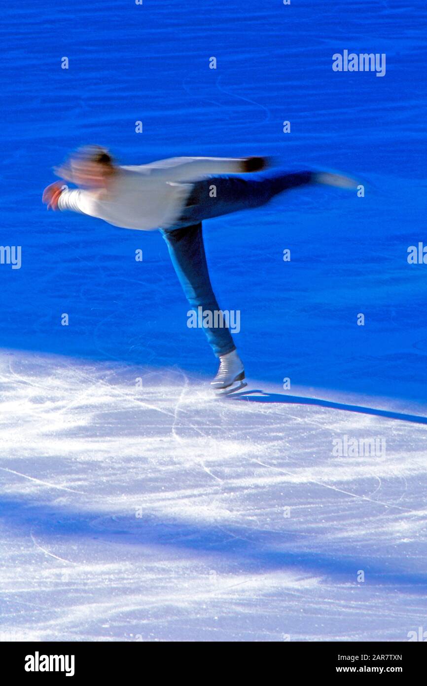 Eiskunstläuferin der Amateure, die Sprünge auf einer Eisbahn im Freien übt Stockfoto